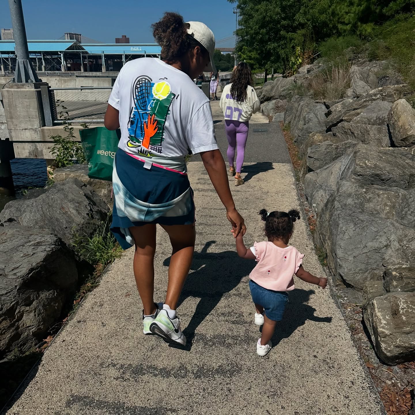 Naomi Osaka holding her daughter's hand as they walk together, posted on January 1, 2025. | Source: Facebook/Naomi Osaka 大坂なおみ﻿