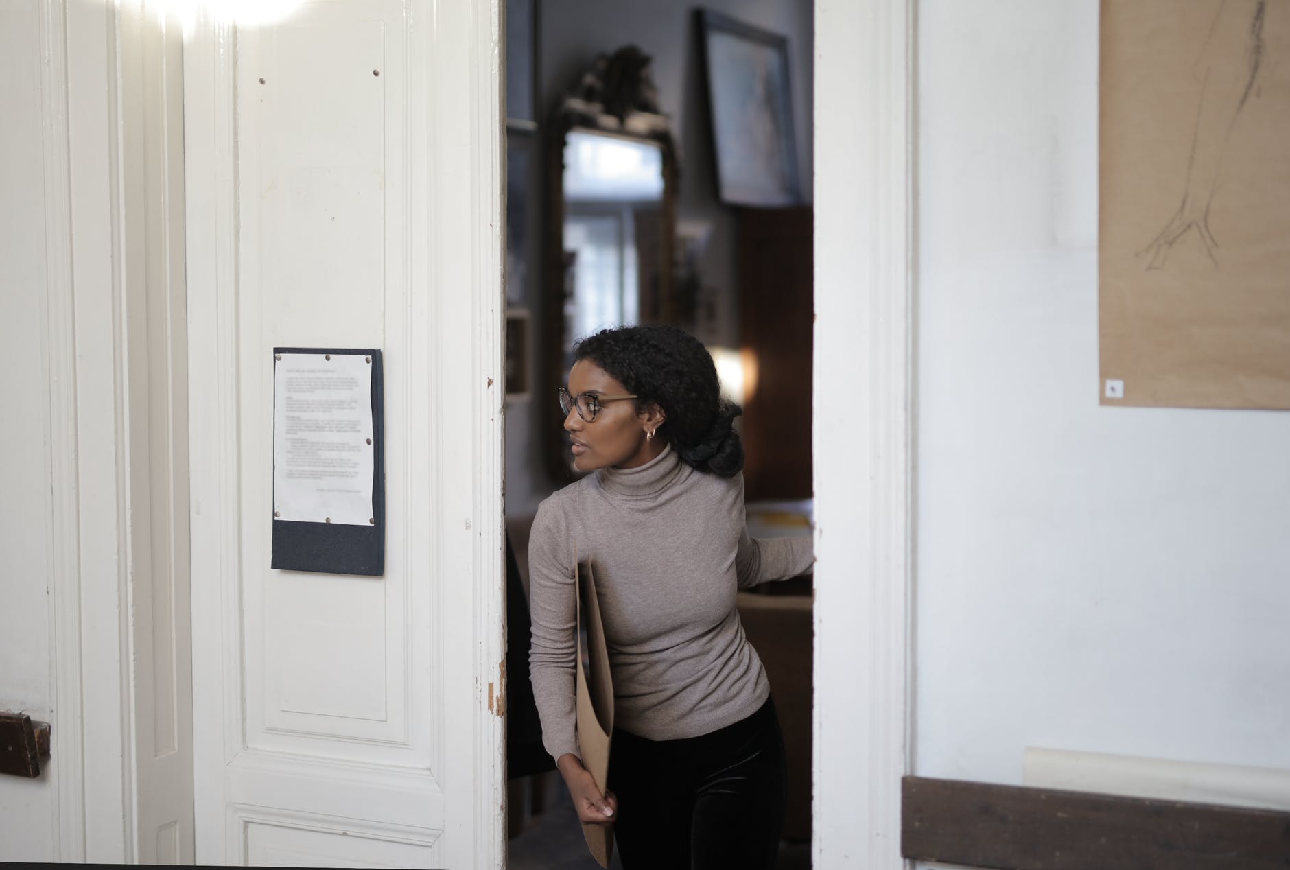 Una joven entrando por una puerta. | Foto: Pexels