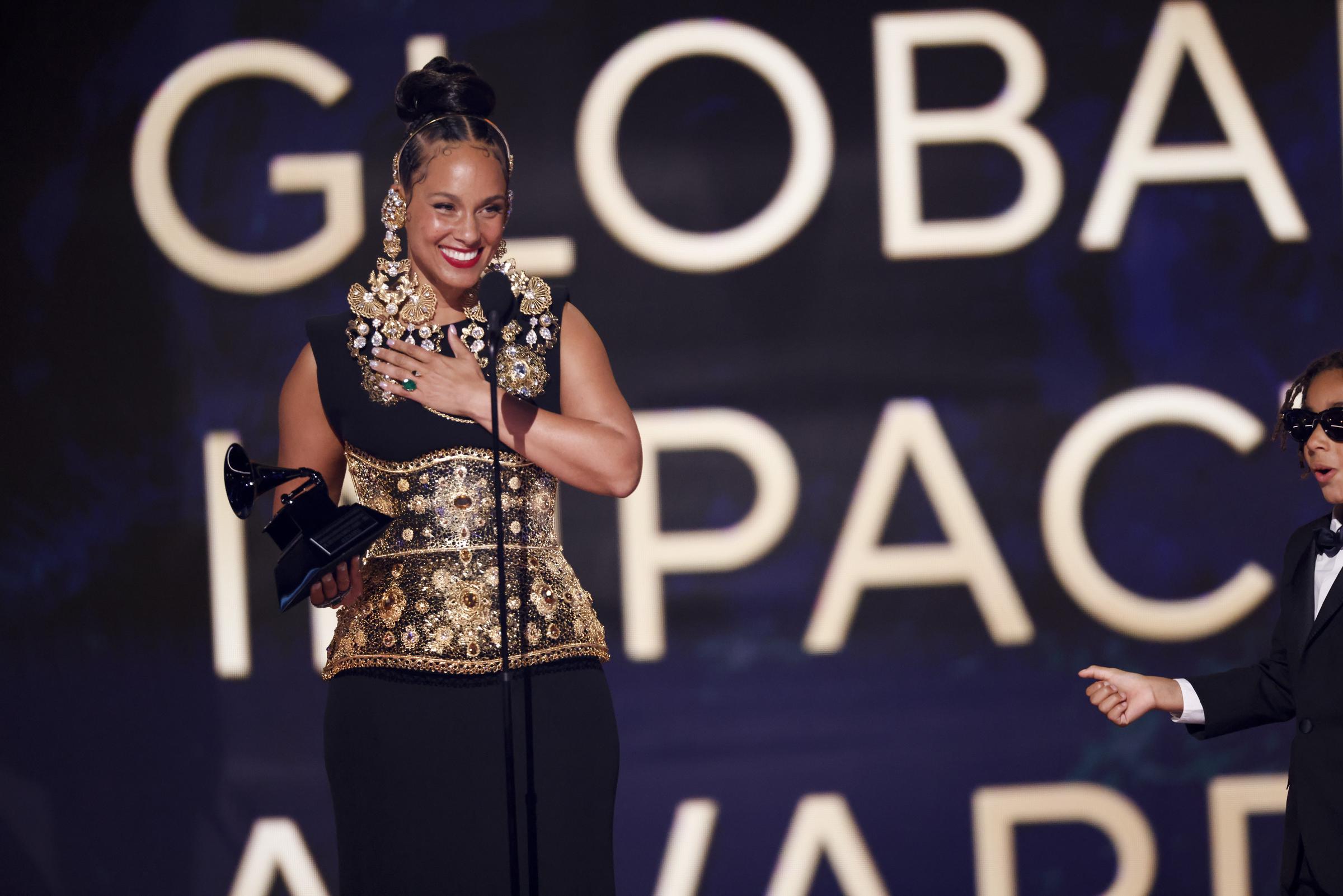 Alicia Keys onstage with her Dr. Dre Global Impact Award and son Genesis Dean. | Source: Getty images