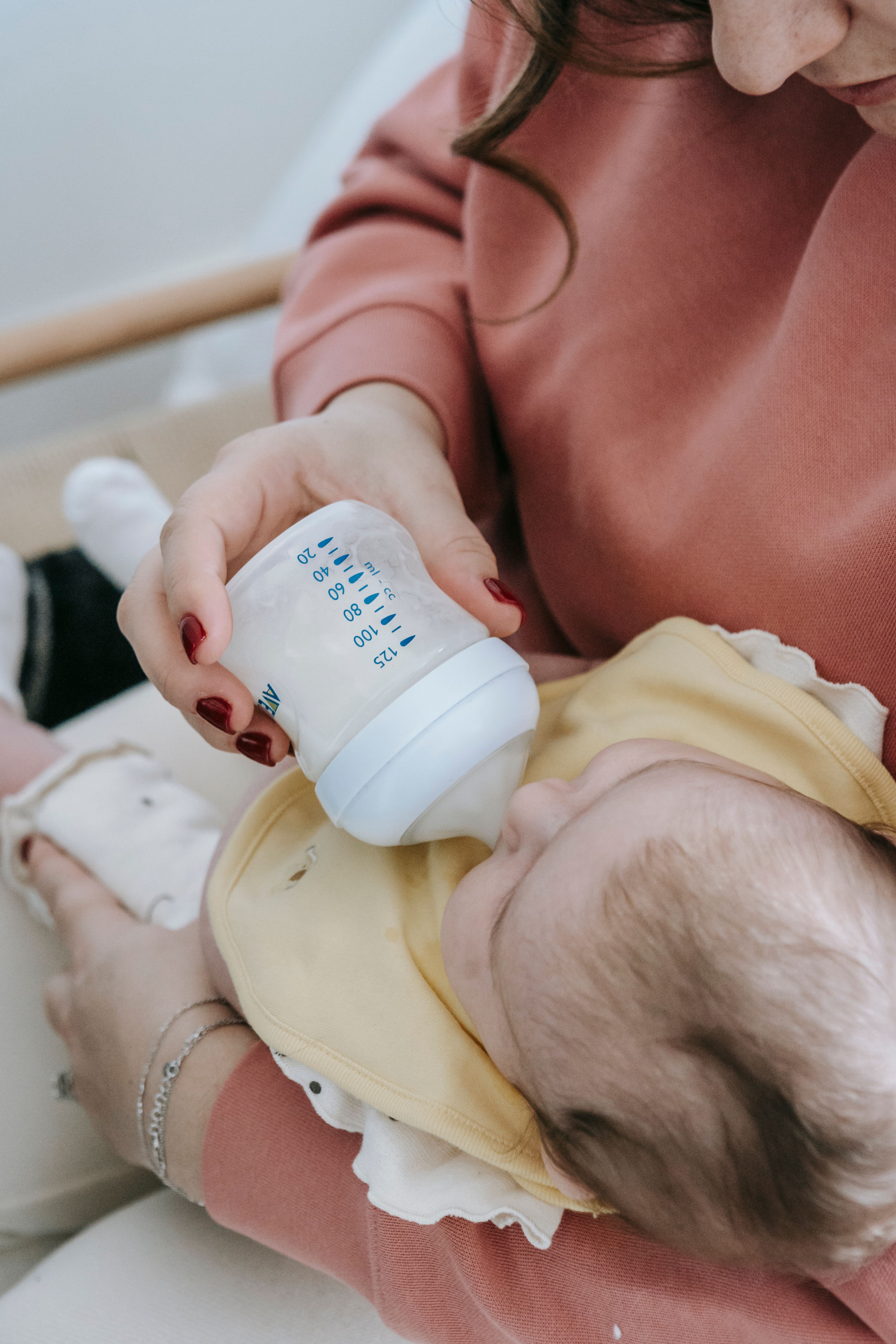 A woman feeding a baby with infant formula | Source: Pexels