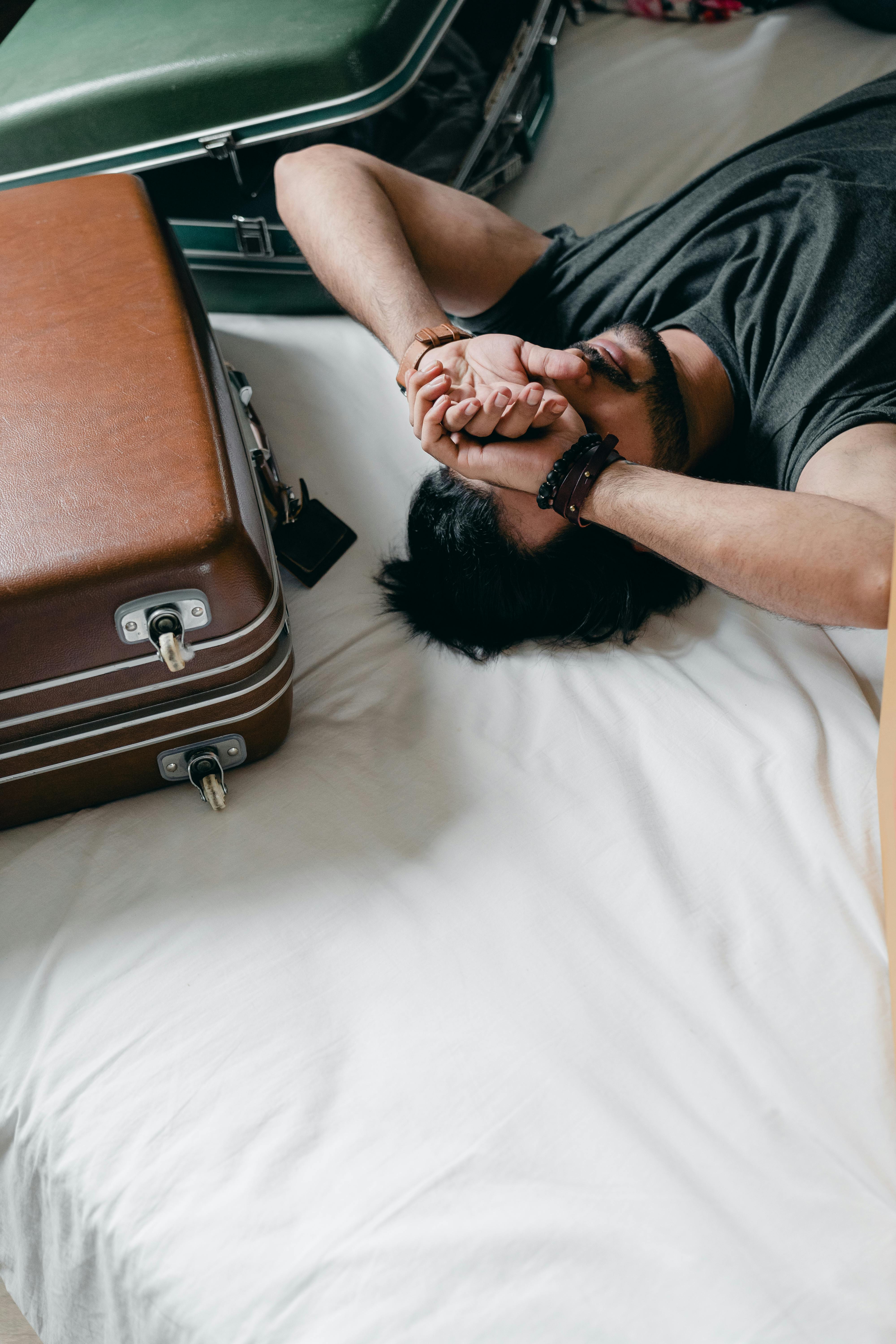 A man taking a break from packing his suitcase | Source: Pexels