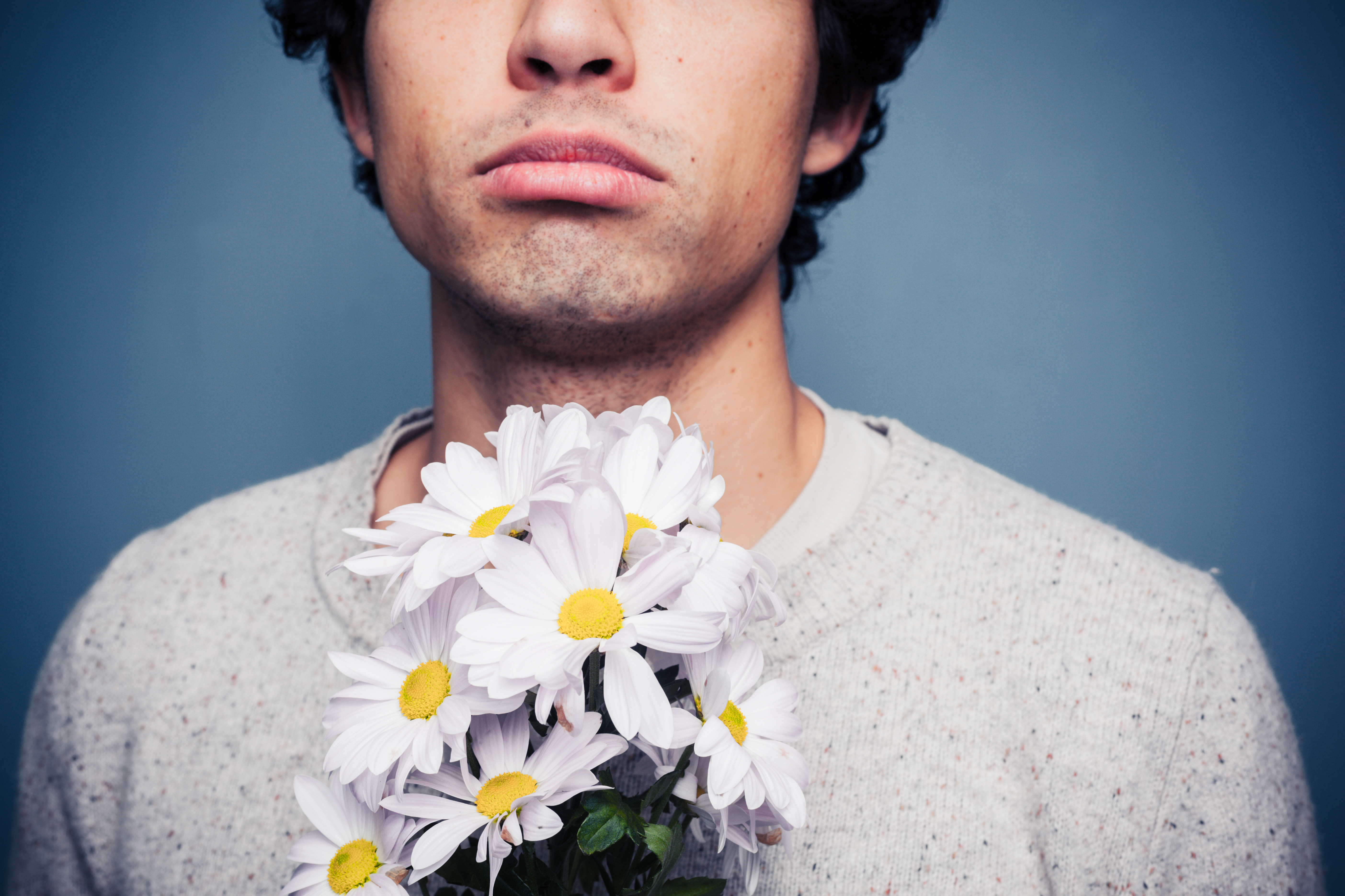 Man standing with flowers | Shutterstock