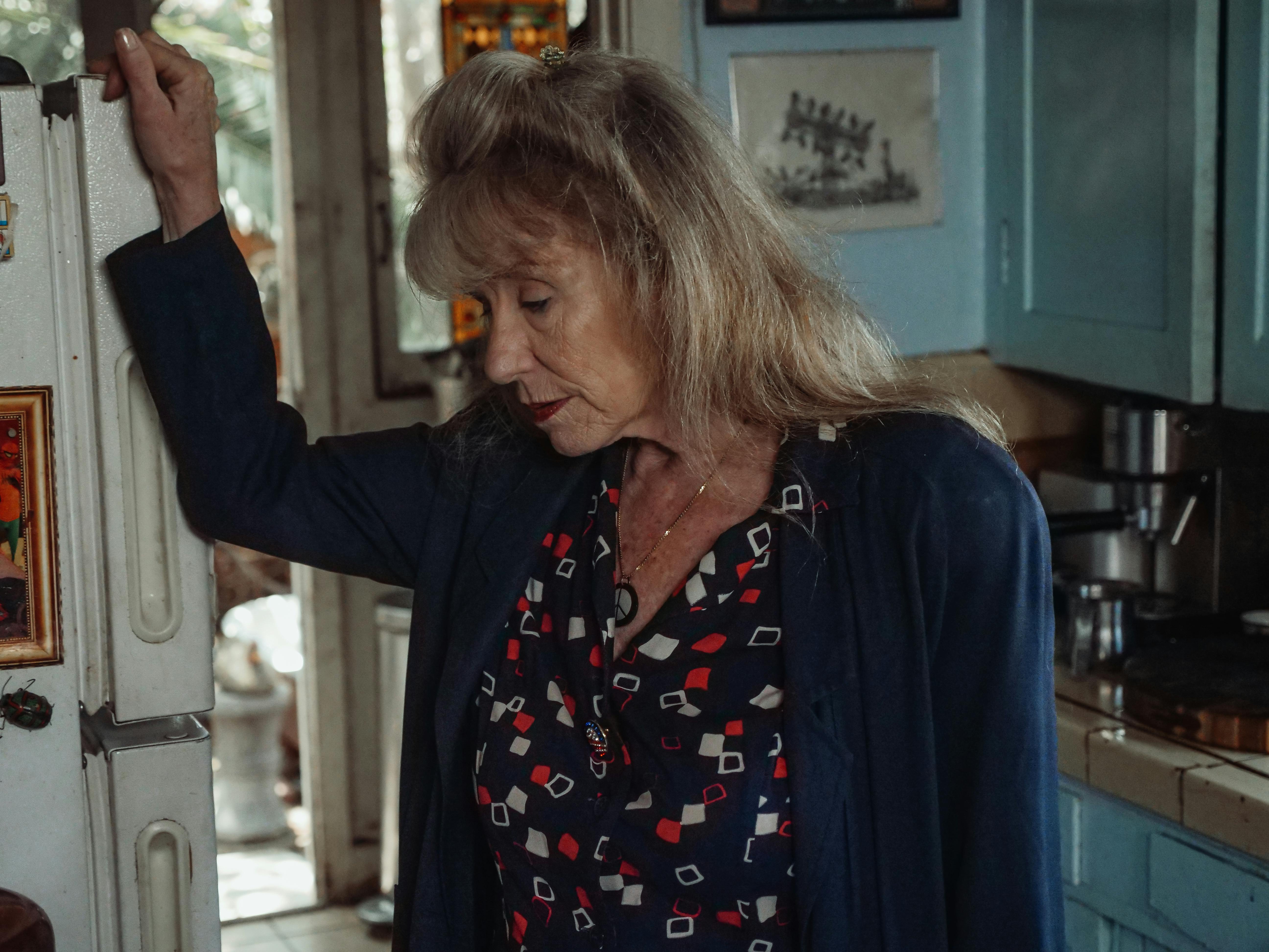 An upset woman standing by a fridge | Source: Pexels