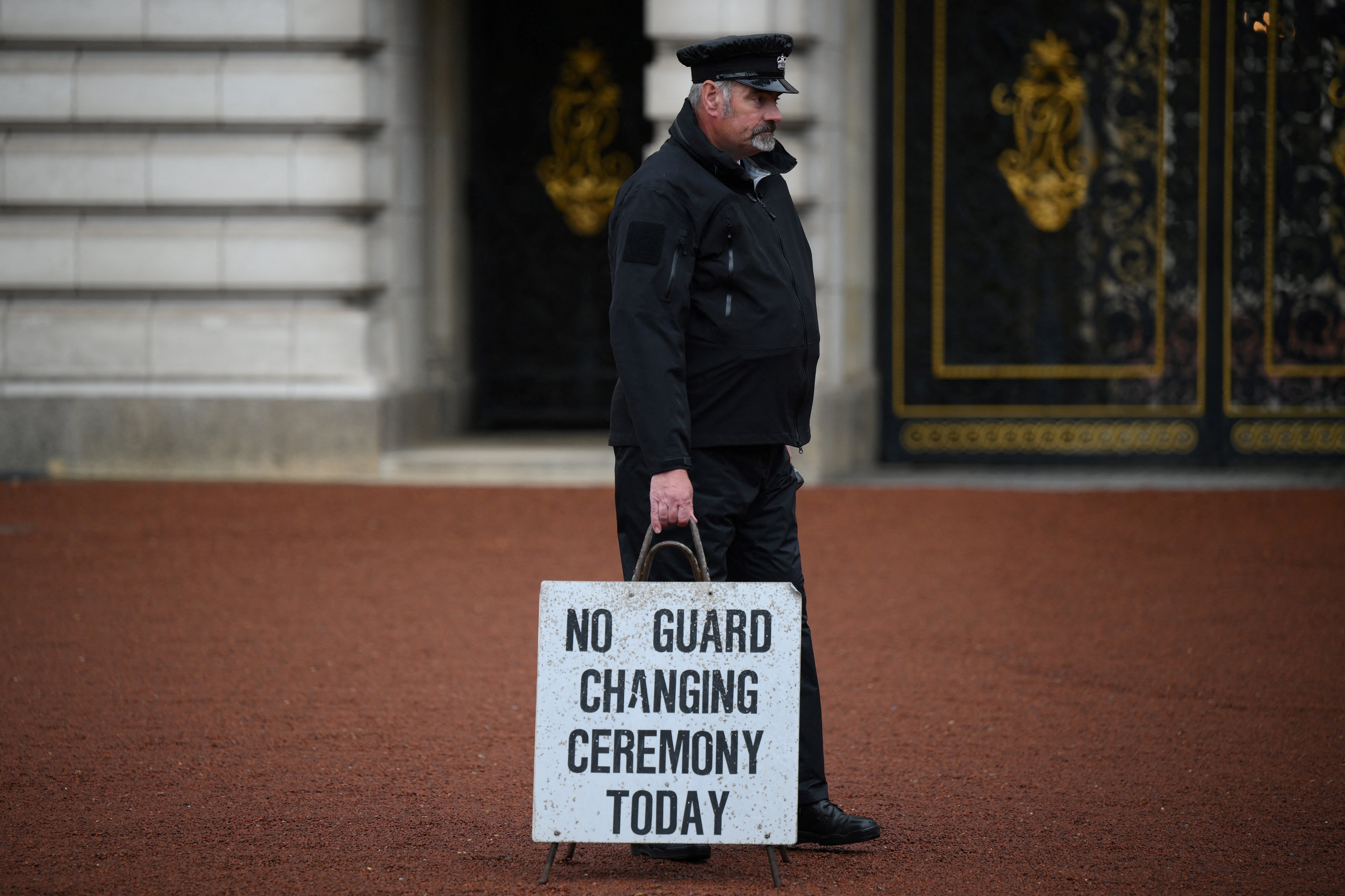 A member of staff holds a board reading "No changing of the guard ceremony today" in the courtyard of Buckingham palace, central London, on September 8, 2022 | Source: Getty Images 
