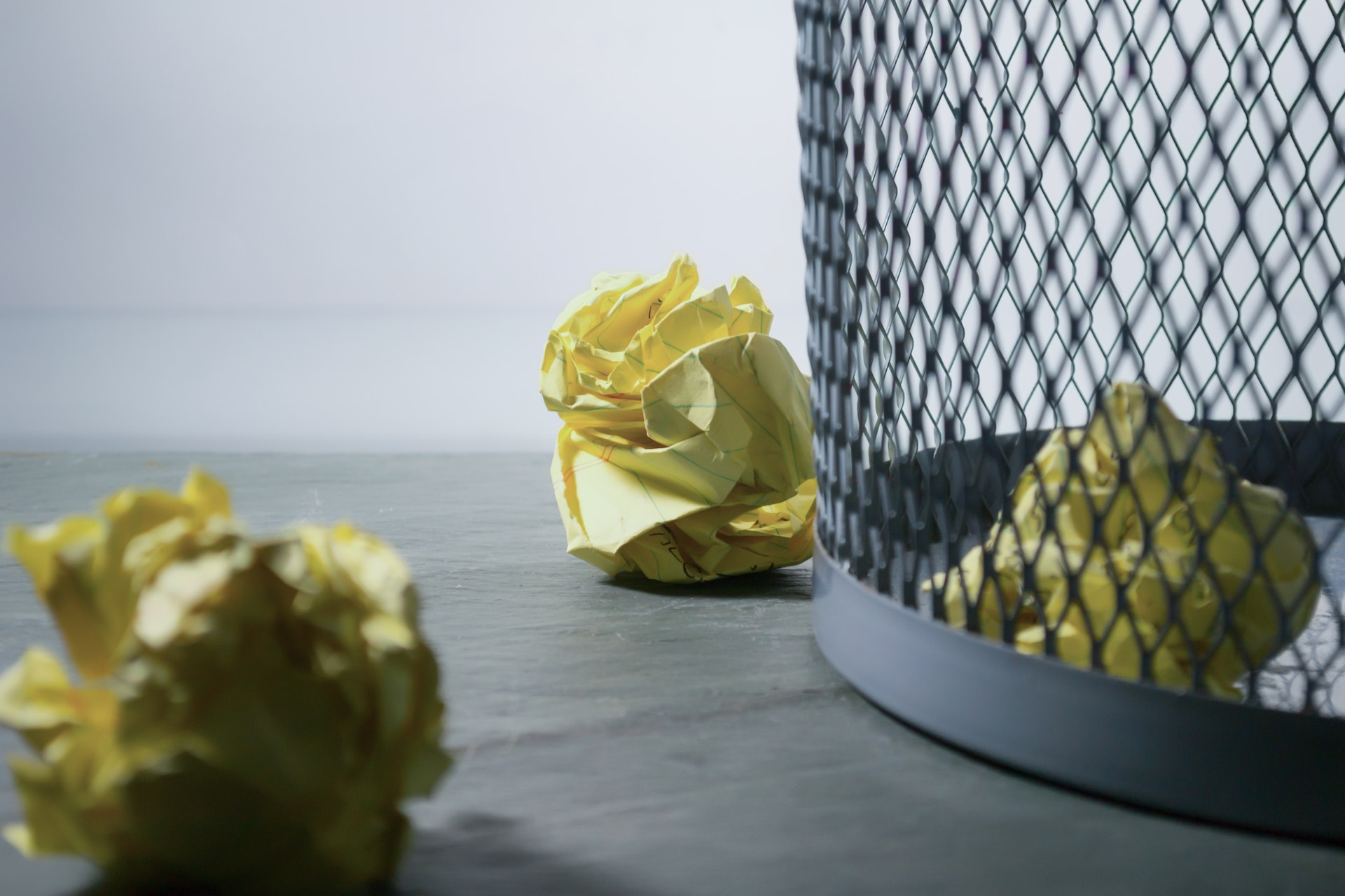 Close-up of paper balls near a trash can | Source: Pexels