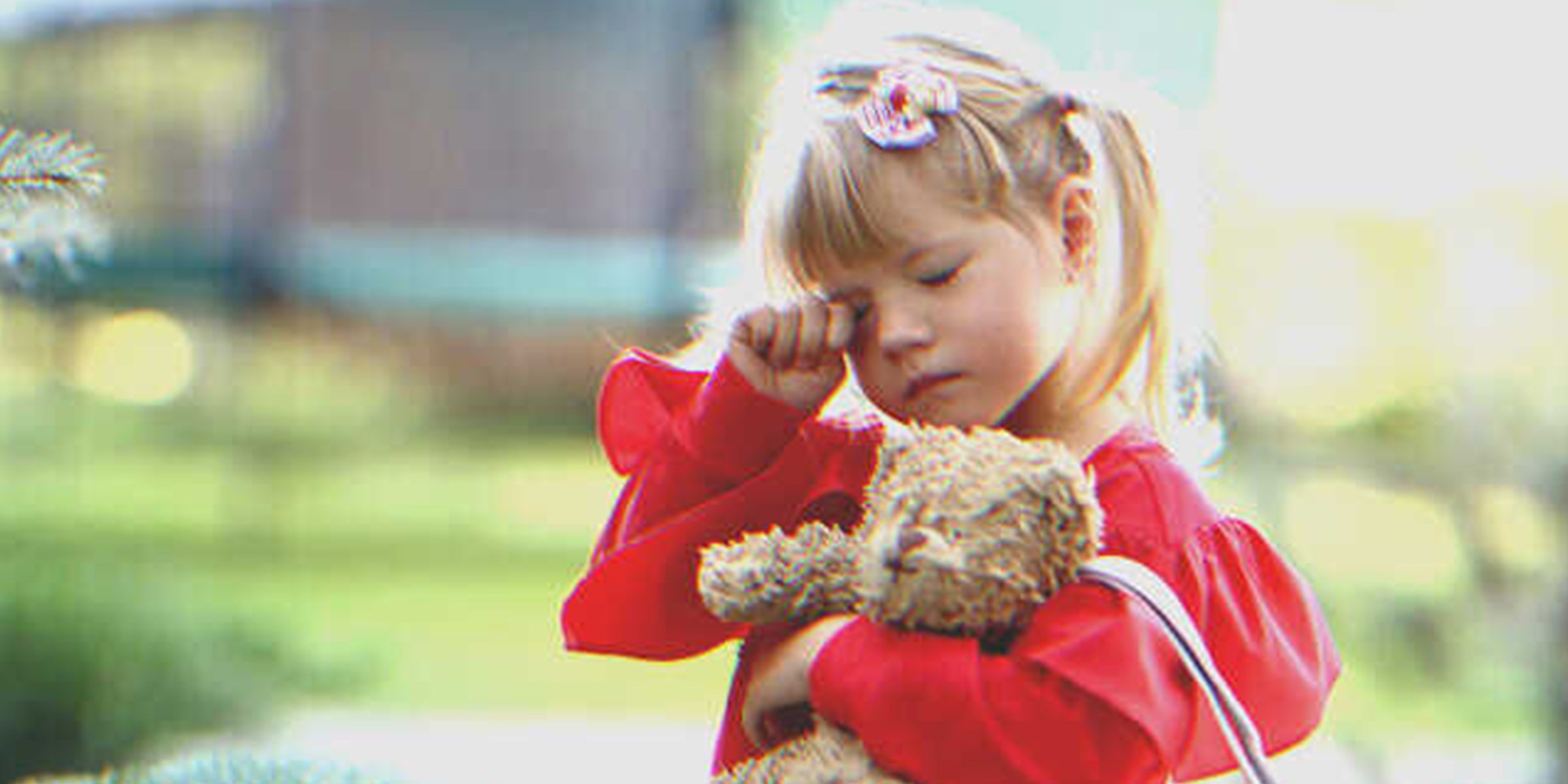 A sleepy girl holding a teddy bear | Source: Shutterstock