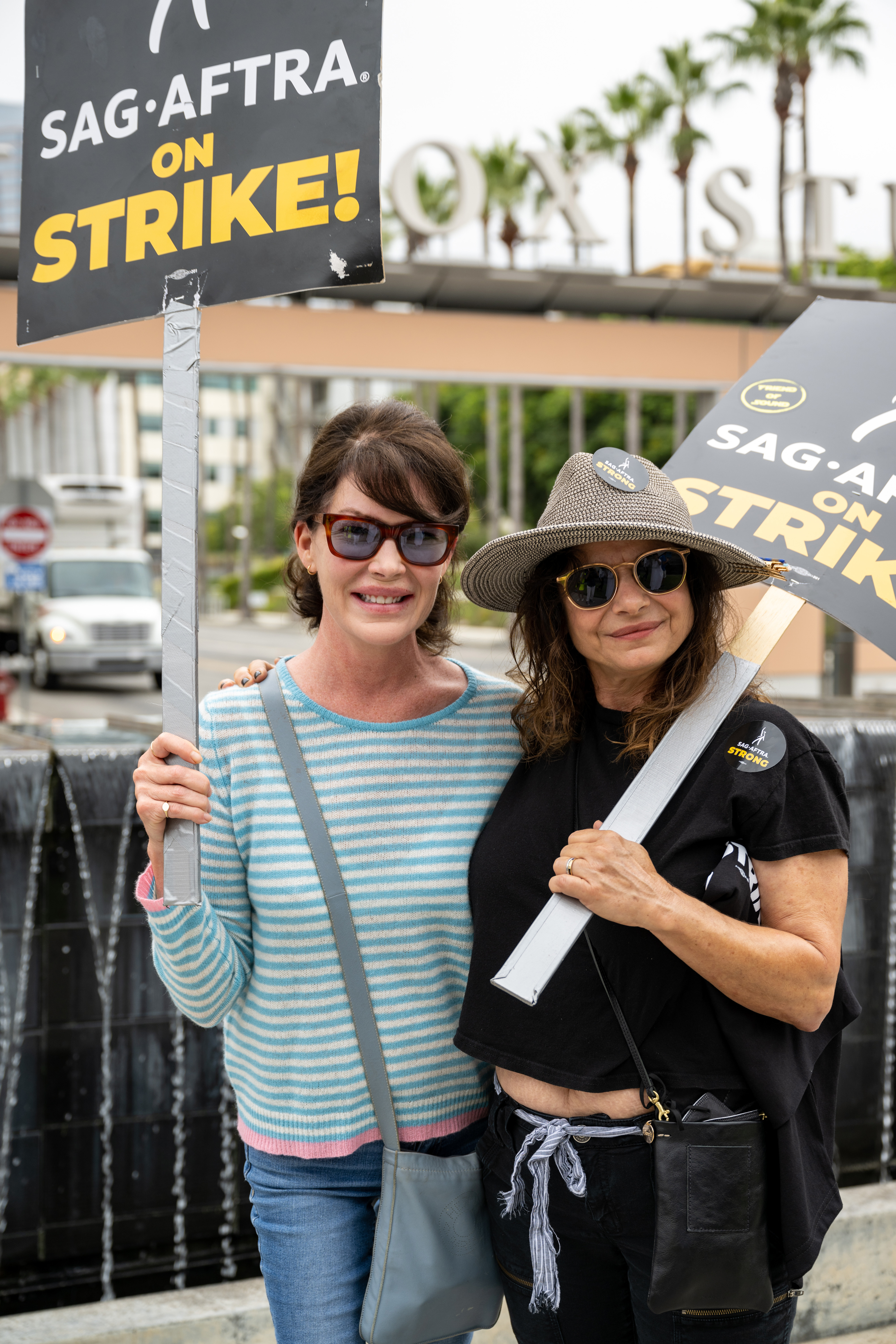 The actress (left) and Laura San Giacomo join members and supporters of SAG-AFTRA and WGA on the picket line at Fox Studios on August 11, 2023 | Source: Getty Images