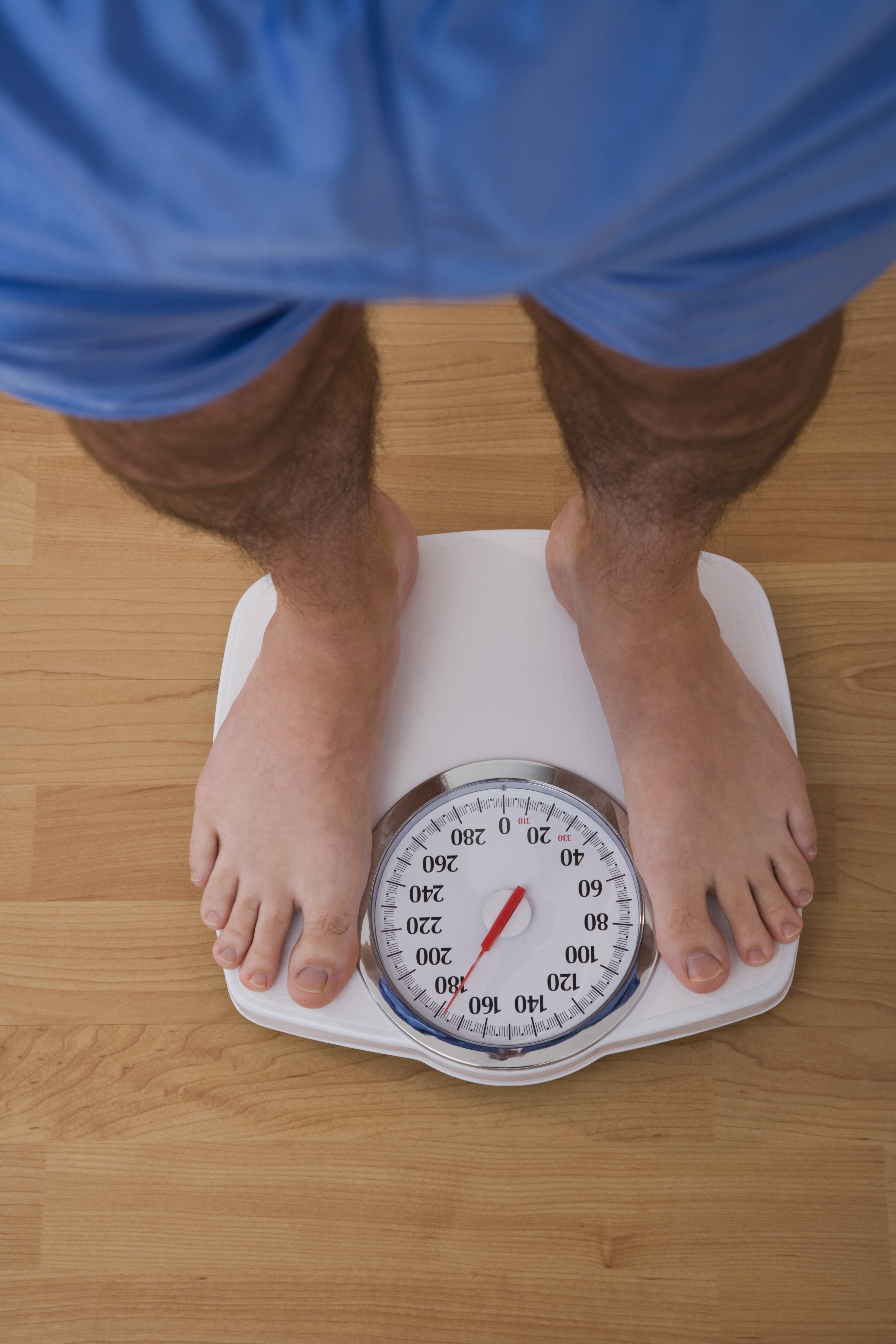 Man standing on weighing scales | Photo : Getty Images