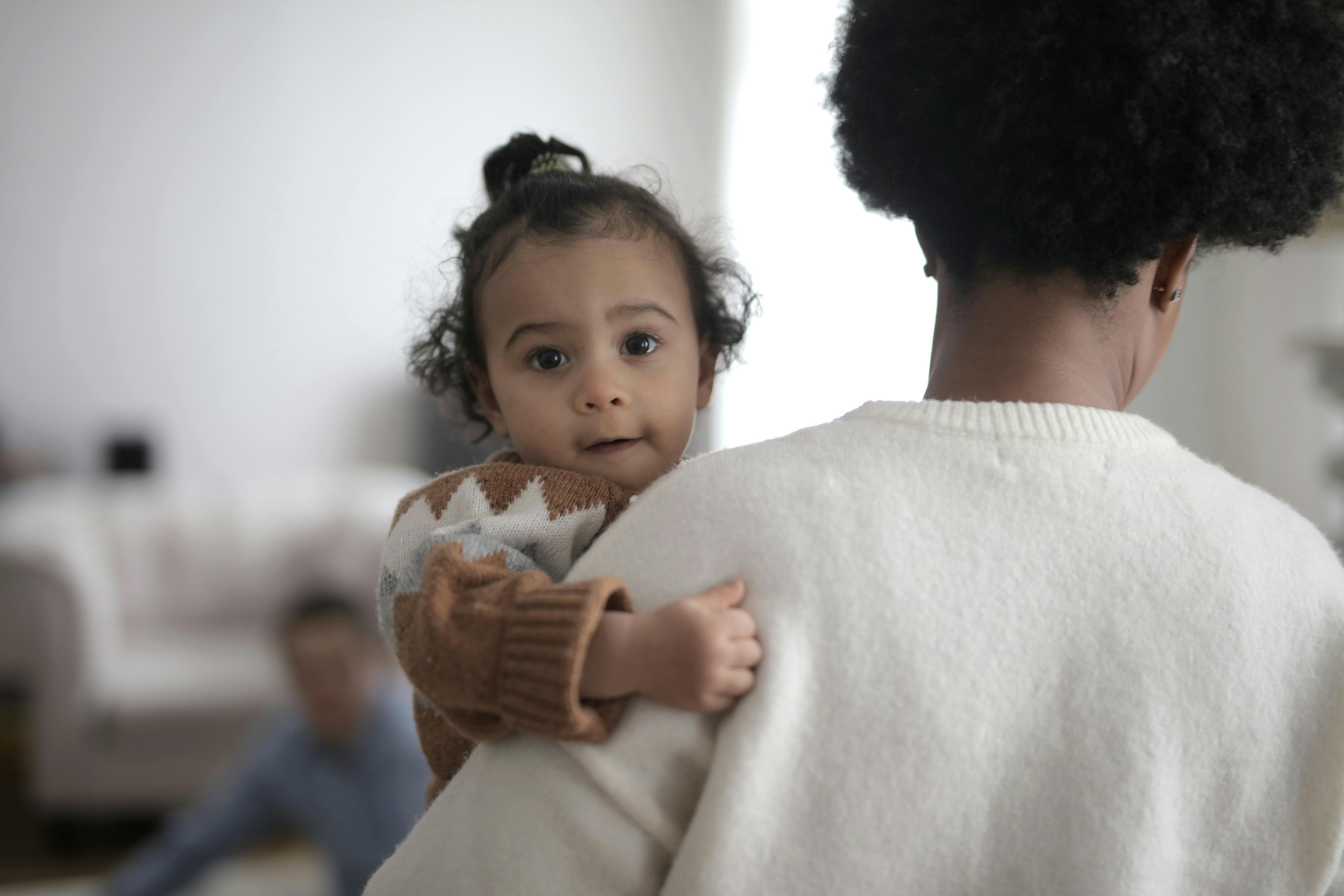 A woman carrying a baby | Source: Pexels