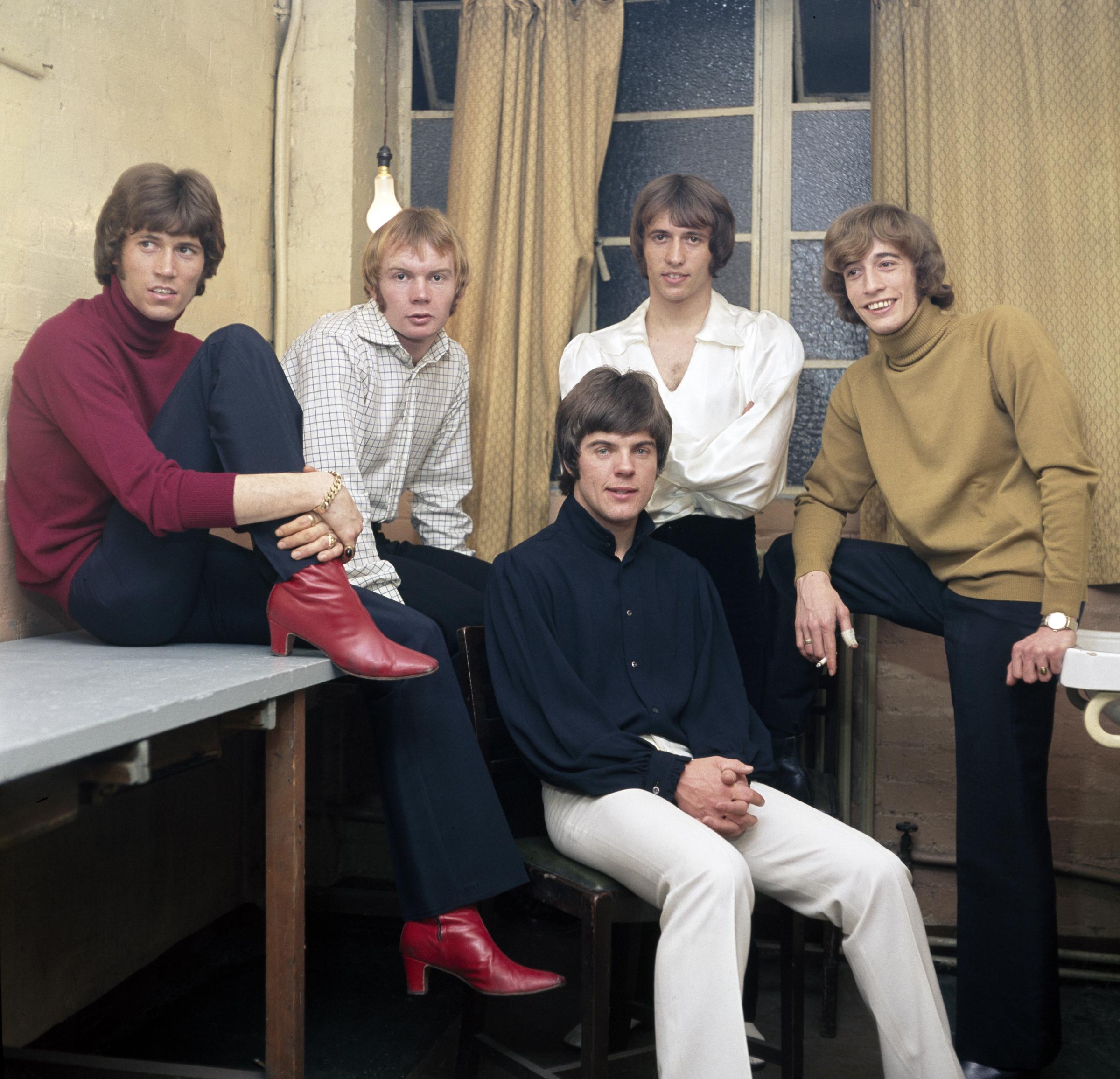 British musical group The Bee Gees (L-R) Barry Gibb, Colin Petersen, Vince Melouney (sitting in front), Maurice Gibb, and Robin Gibb, photographed in London, England, circa 1968 | Source: Getty Images