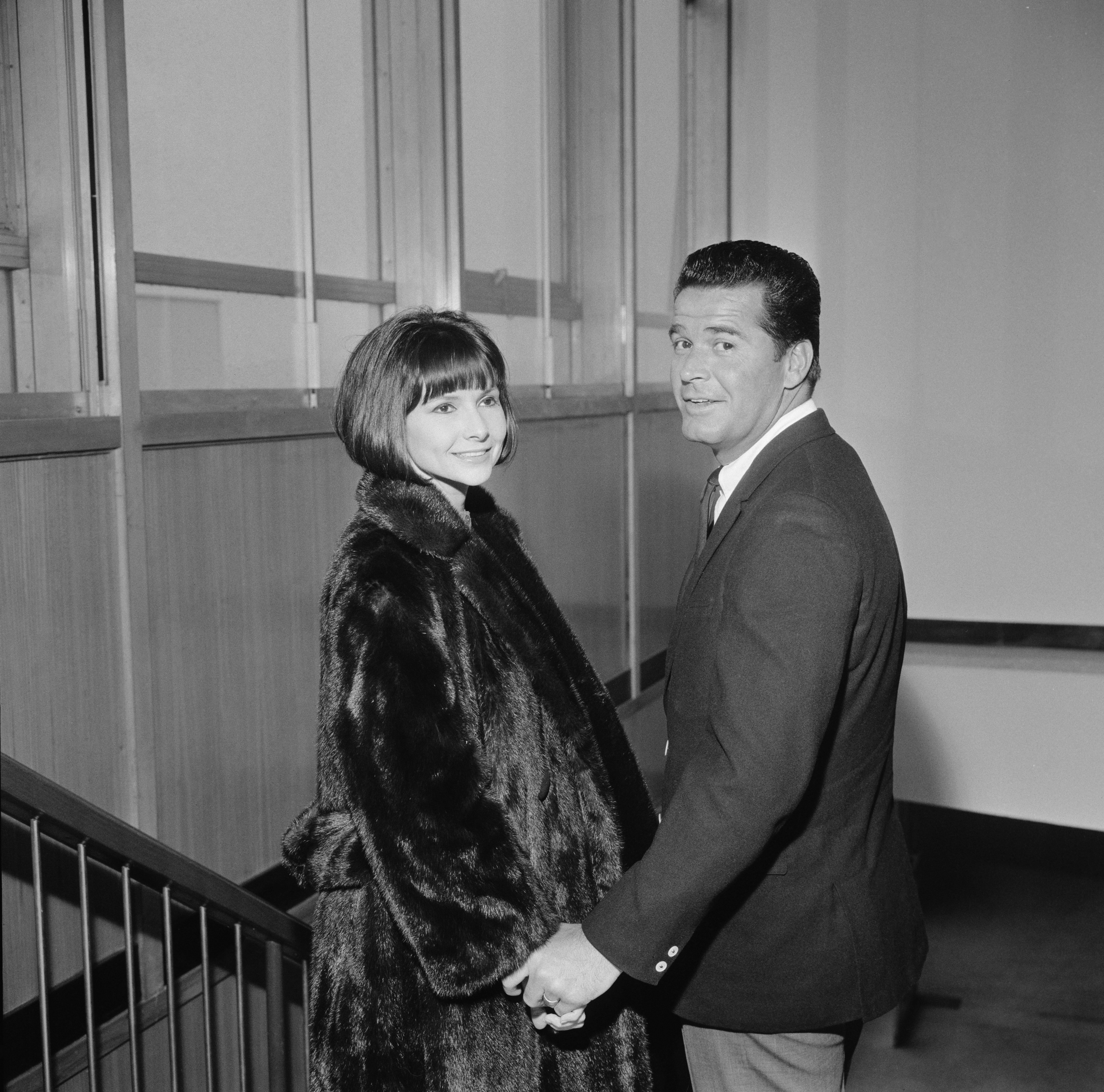 James Garner and Lois Clarke photographed holding hands on a staircase on March 1, 1964 in the United Kingdom | Source: Getty Images