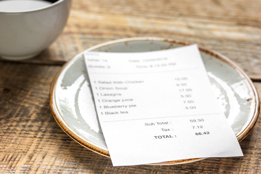 Recibo de pago sobre un pequeño plato en una mesa. | Foto: Shutterstock