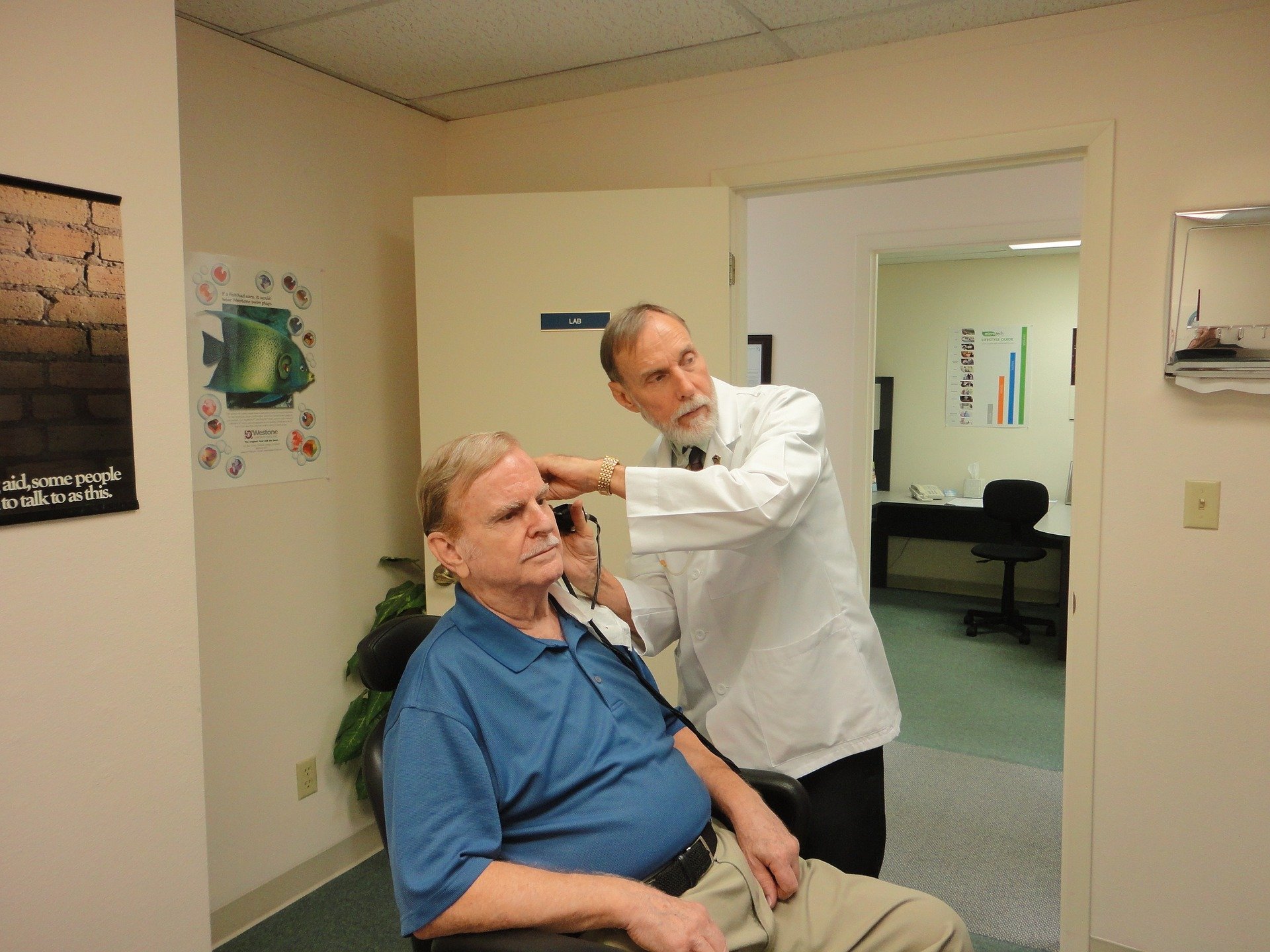 An elderly man having his ears tested by a doctor | Photo: Pixabay/williamsje1