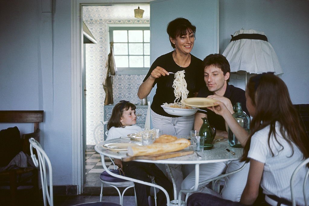 . Hugues AUFRAY à table avec sa femme Hélène et leurs deux filles Charlotte et Marie | photo : Getty Images