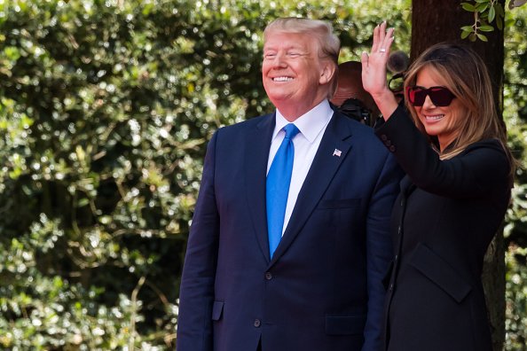 Le président des États-Unis, Donald Trump, à gauche, réagit aux côtés de la Première Dame, Melania Trump, lors d'une cérémonie au cimetière et mémorial américain de Normandie à Colleville-sur-Mer, France | Photo: Getty Images