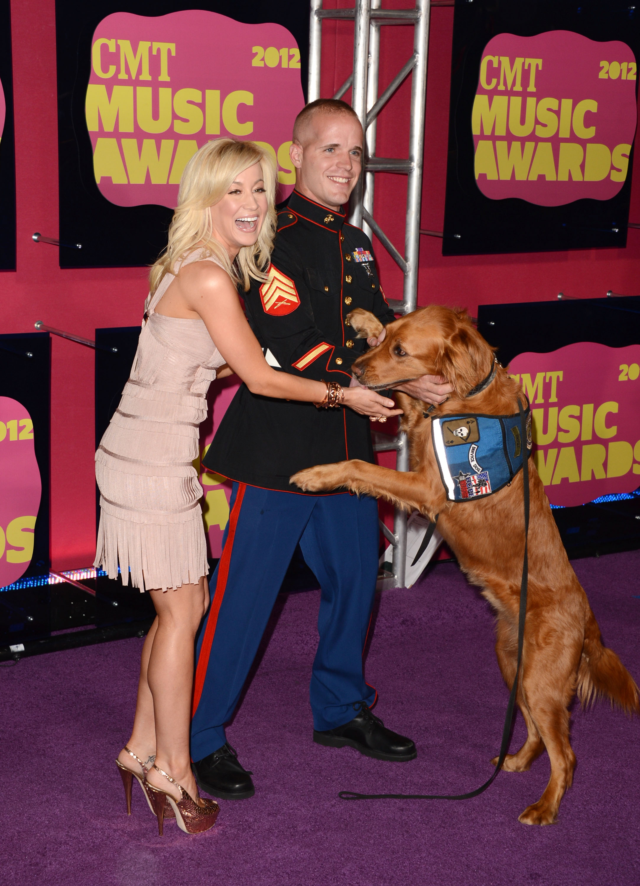 Kellie Pickler greets a service dog alongside Nigel Max Edge while arriving at Country Music Television (CMT) Awards on June 6, 2012 | Source: Getty Images