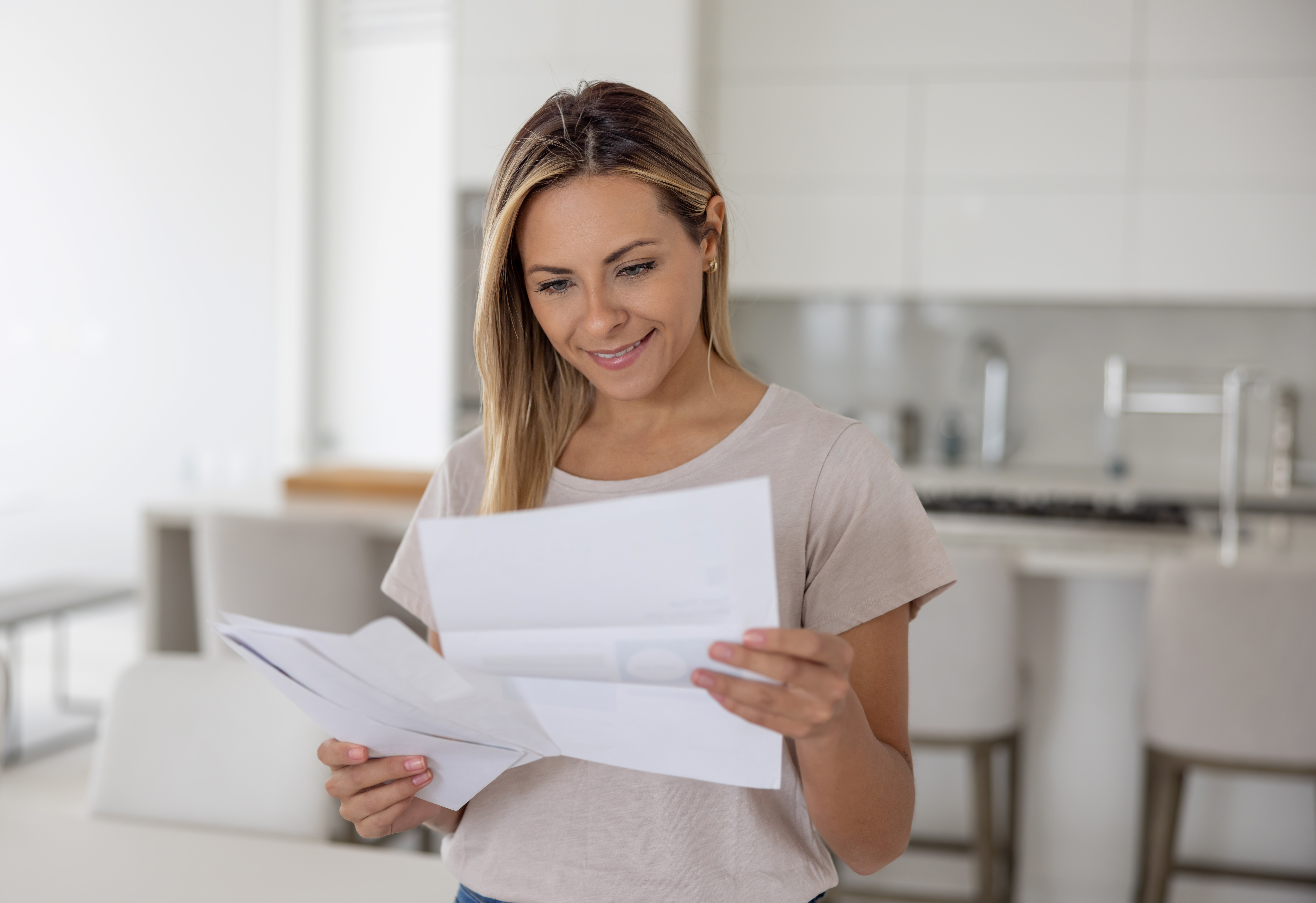 Woman at home reading a letter in her mail | Source: Getty Images