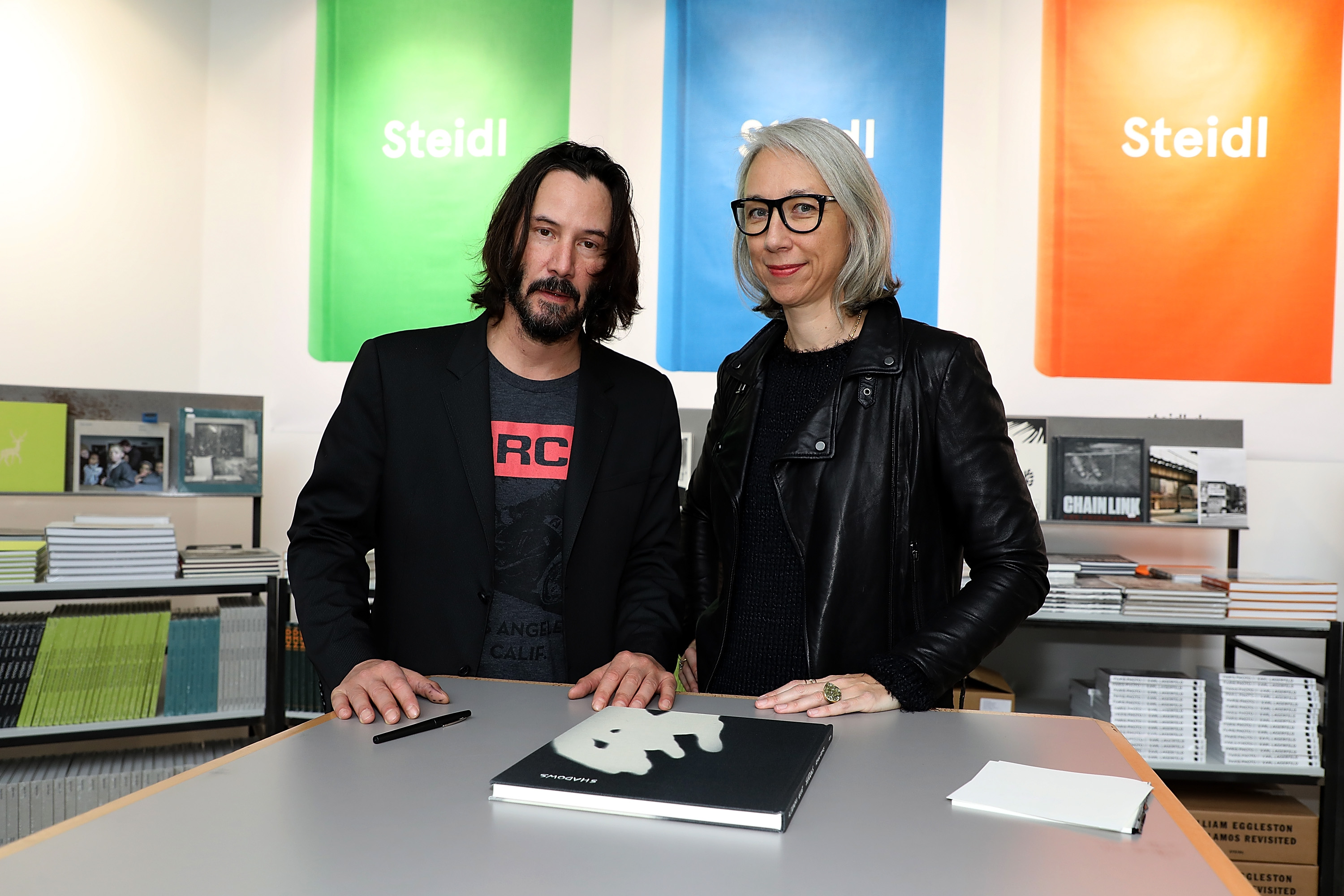 Keanu Reeves and Alexandra Grant posing with their book "Ode to Happiness" at le Grand Palais in Paris, France on November 10, 2017. | Source: Getty Images