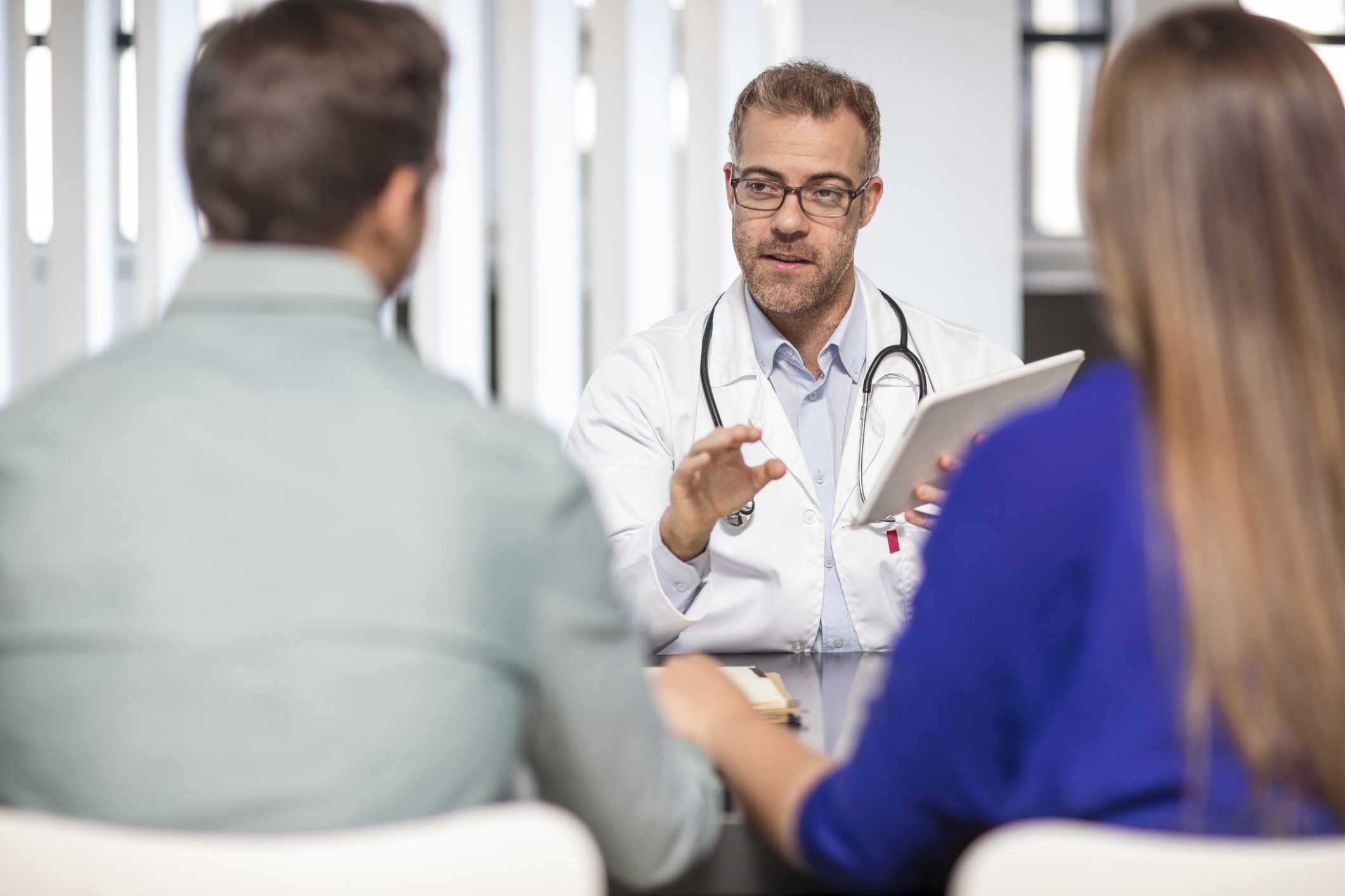 Doctor talking to couple in medical practice | Photo: Getty Images