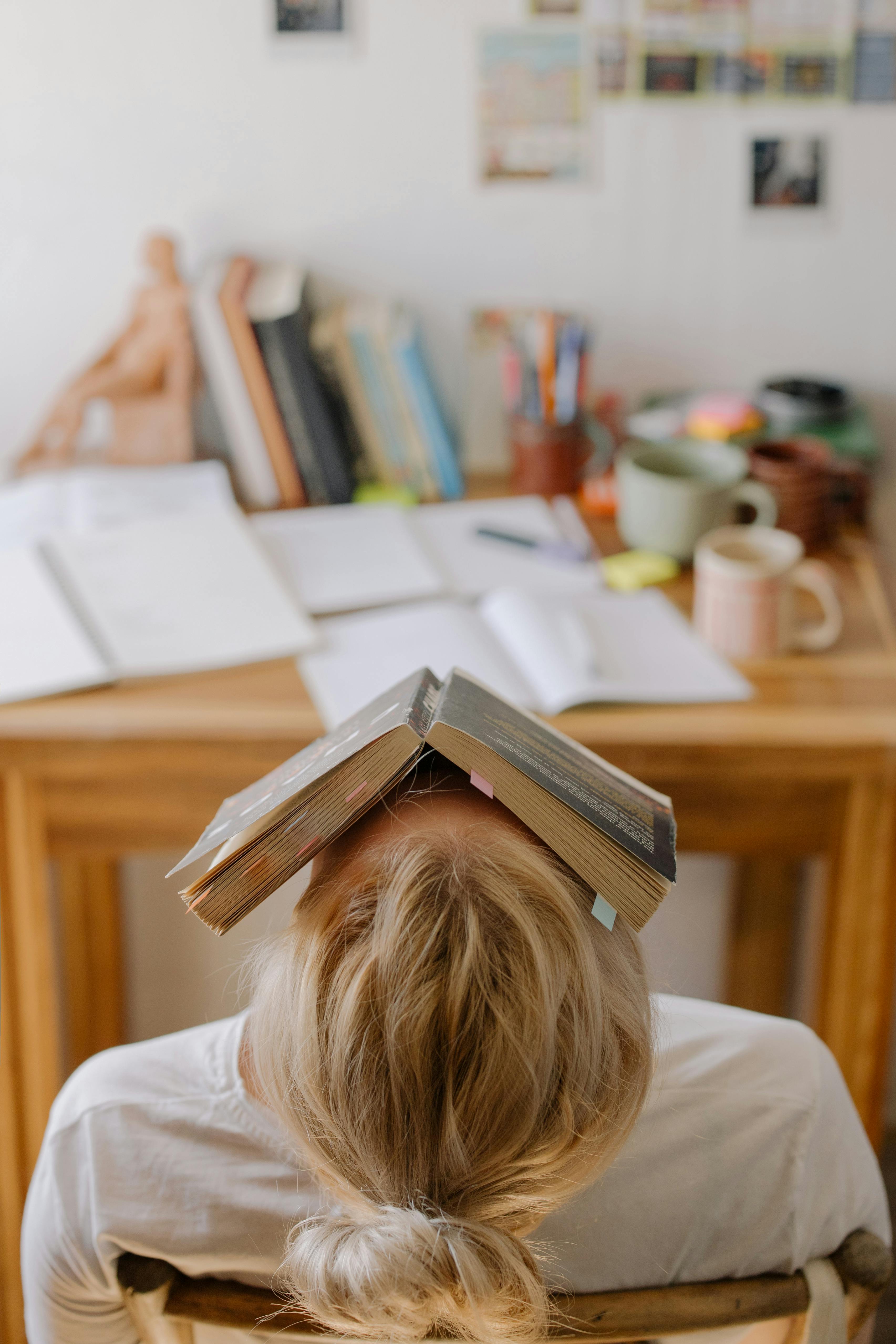 A tired student with a book | Source: Pexels