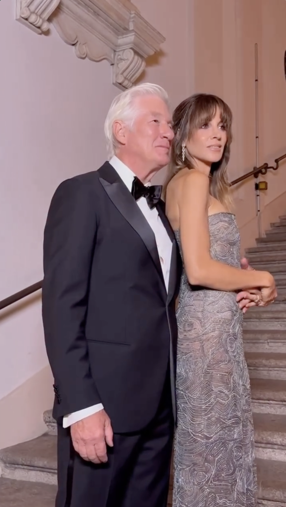 Richard Gere and Alejandra Silva pose on the grand staircase, their polished looks and poised presence echoing the sophistication of the night. | Source: Instagram/voguemagazine