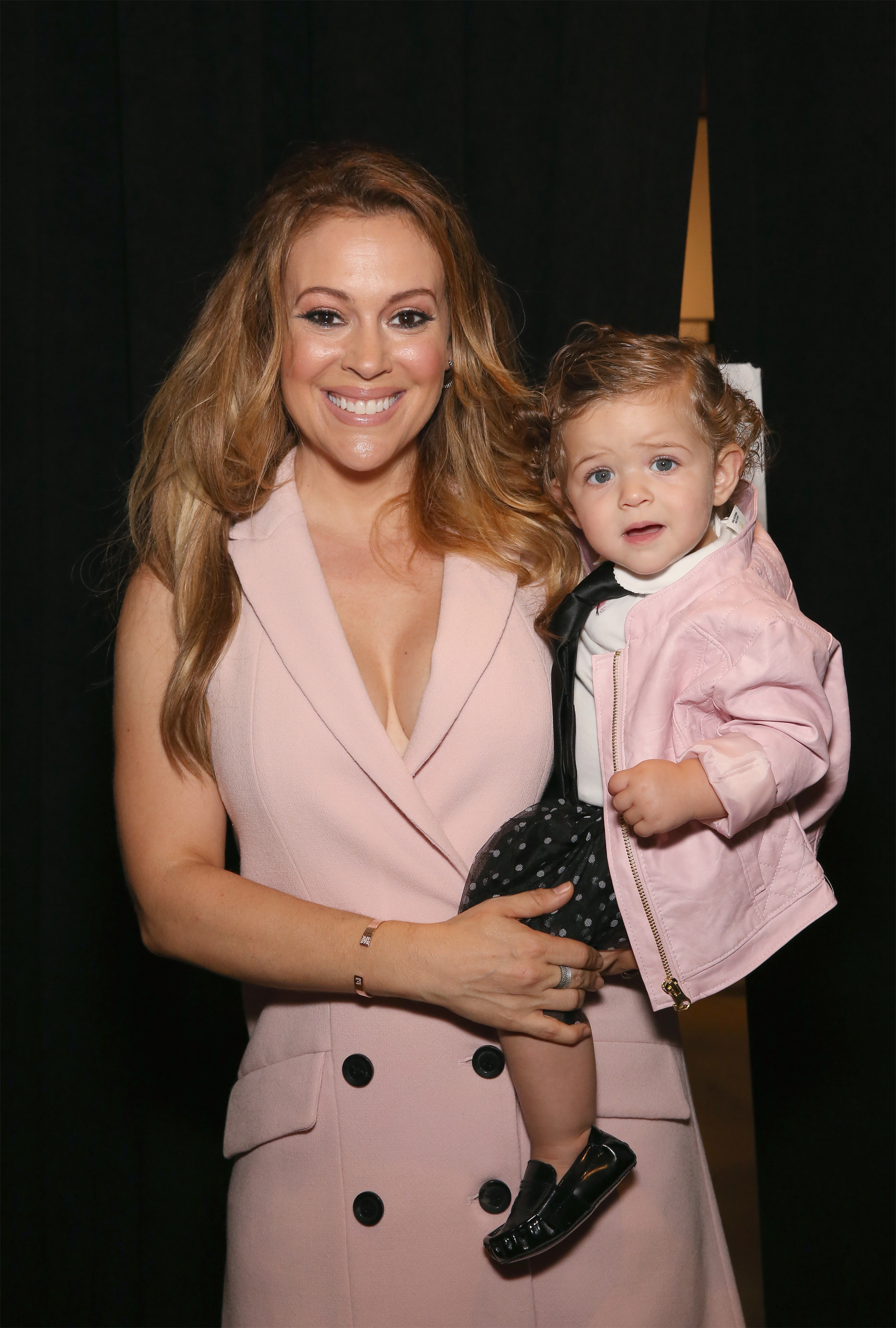 Alyssa Milano and her daughter Elizabella pose backstage before the Marissa Webb Fashion Show during Spring MADE Fashion Week on September 10, 2015, in New York City | Source: Getty Images