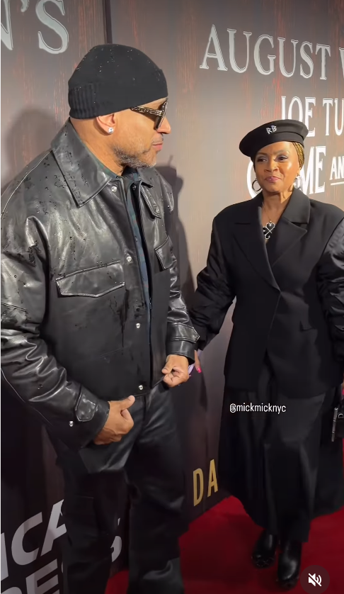 LL Cool J turns toward Simone Smith at the opening night of "Joe Turner's Come and Gone," as she stands beside him in a structured black outfit and beret. | Source: Instagram/mickmicknyc