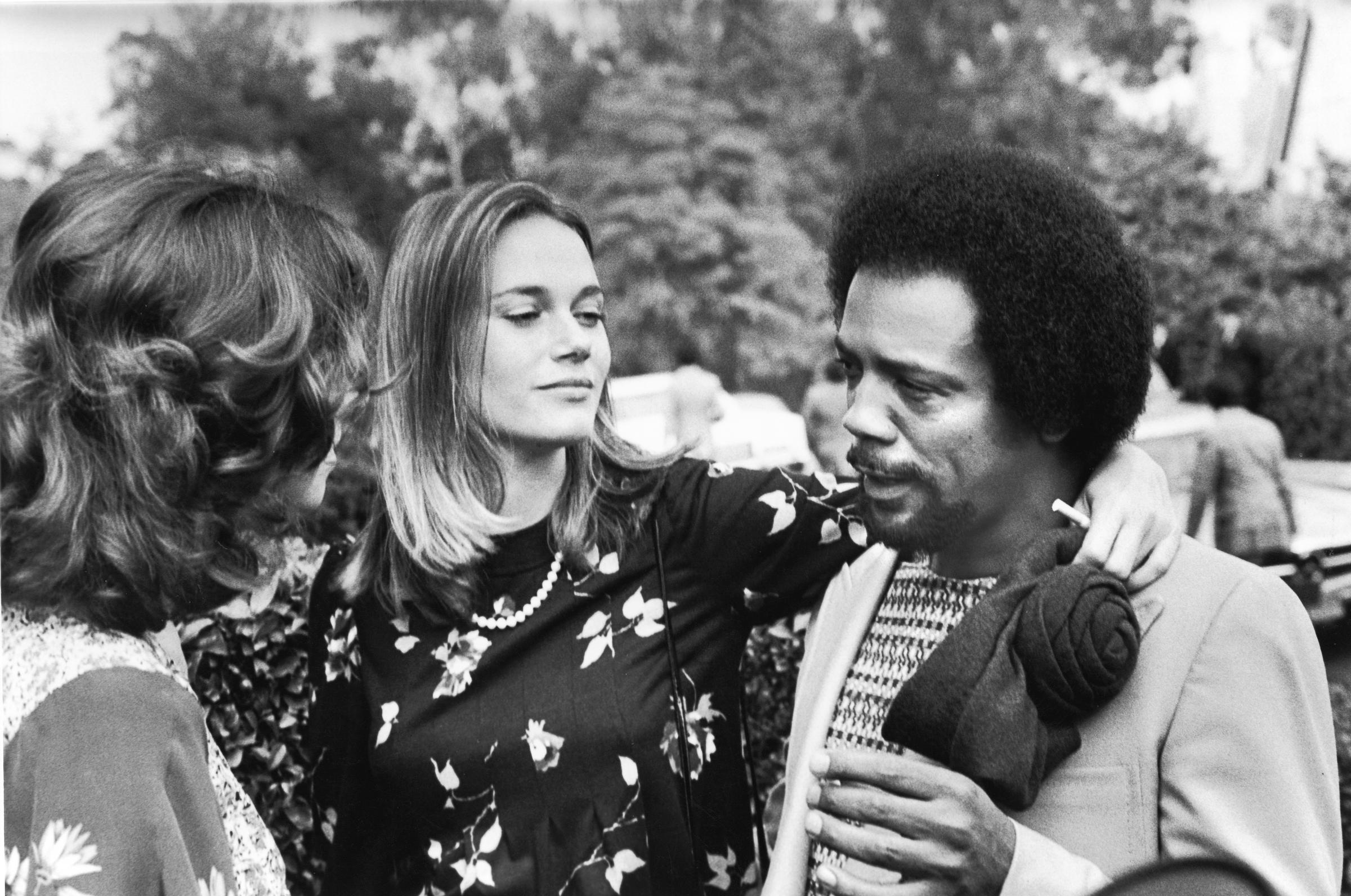 Actress Peggy Lipton puts her arm around the shoulders of Quincy Jones as he talks to another woman in Bel Air, Los Angeles, California, on October 1973 | Source: Getty Images