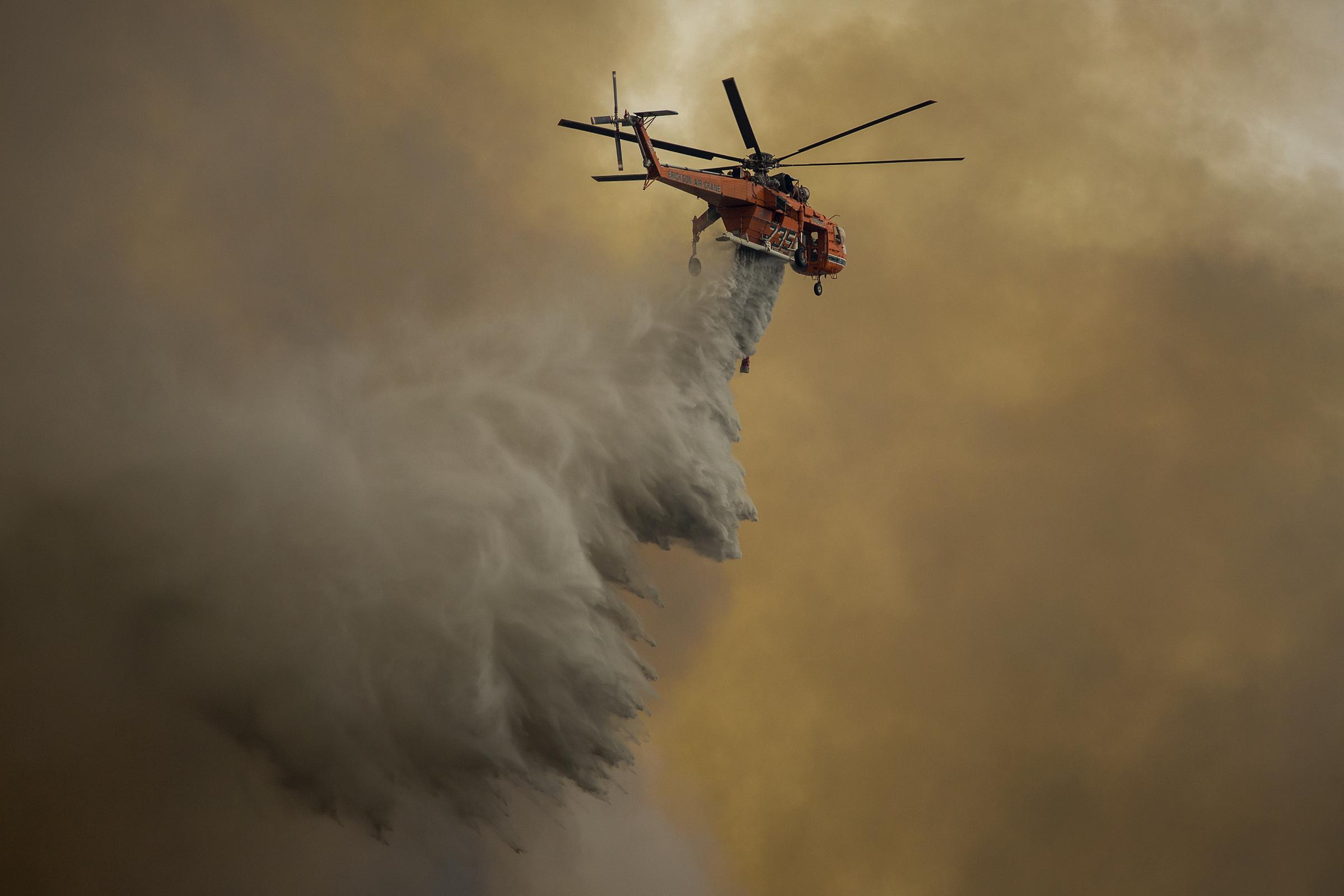 An Erickson Air Crane firefighting helicopter drops water over the La Tuna Fire near Burbank, California, on September 2, 2017 | Source: Getty Images