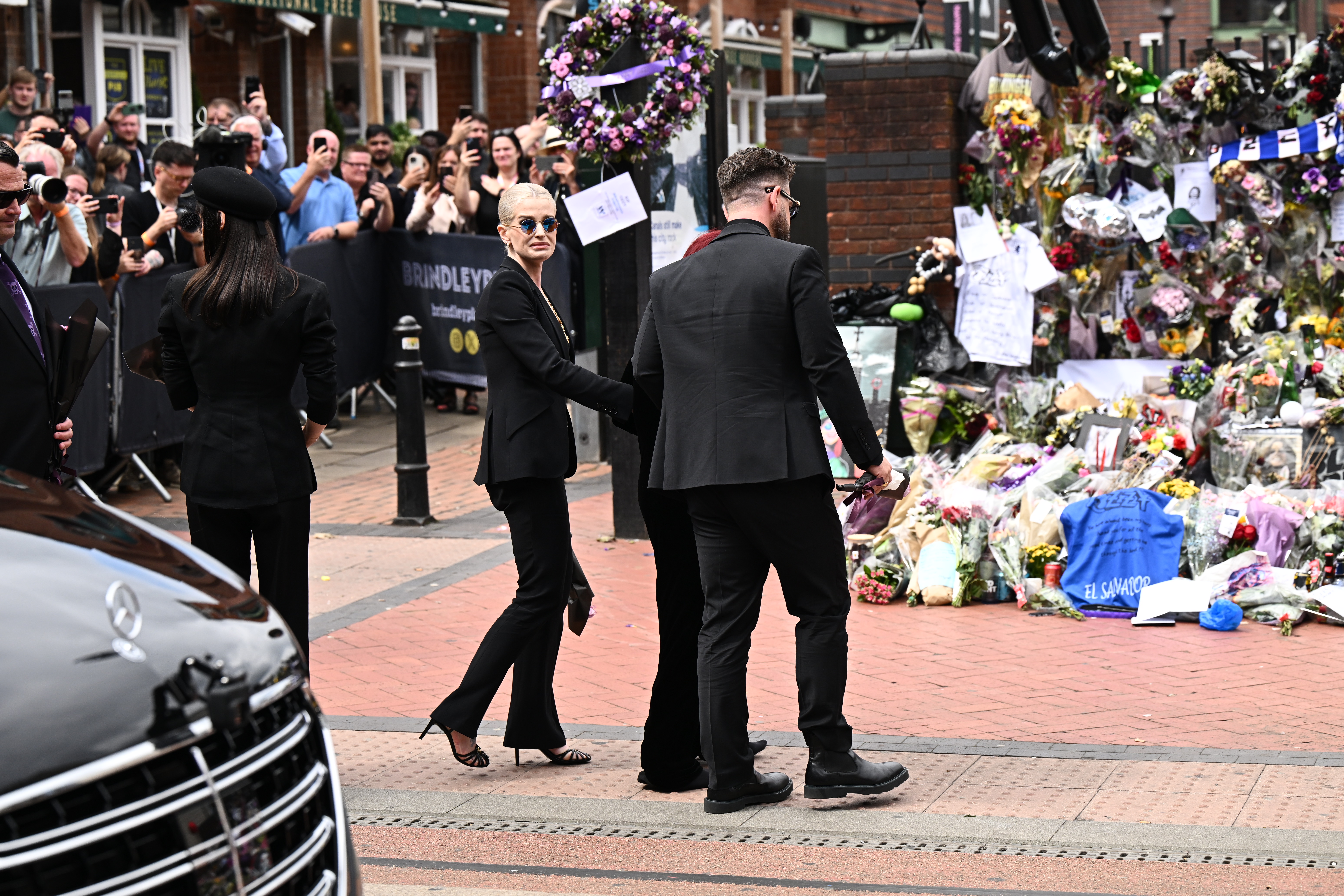 Kelly and Jack Osbourne walk with their mother Sharon to view fan tributes to Ozzy in Birmingham on July 30, 2025. | Source: Getty Images