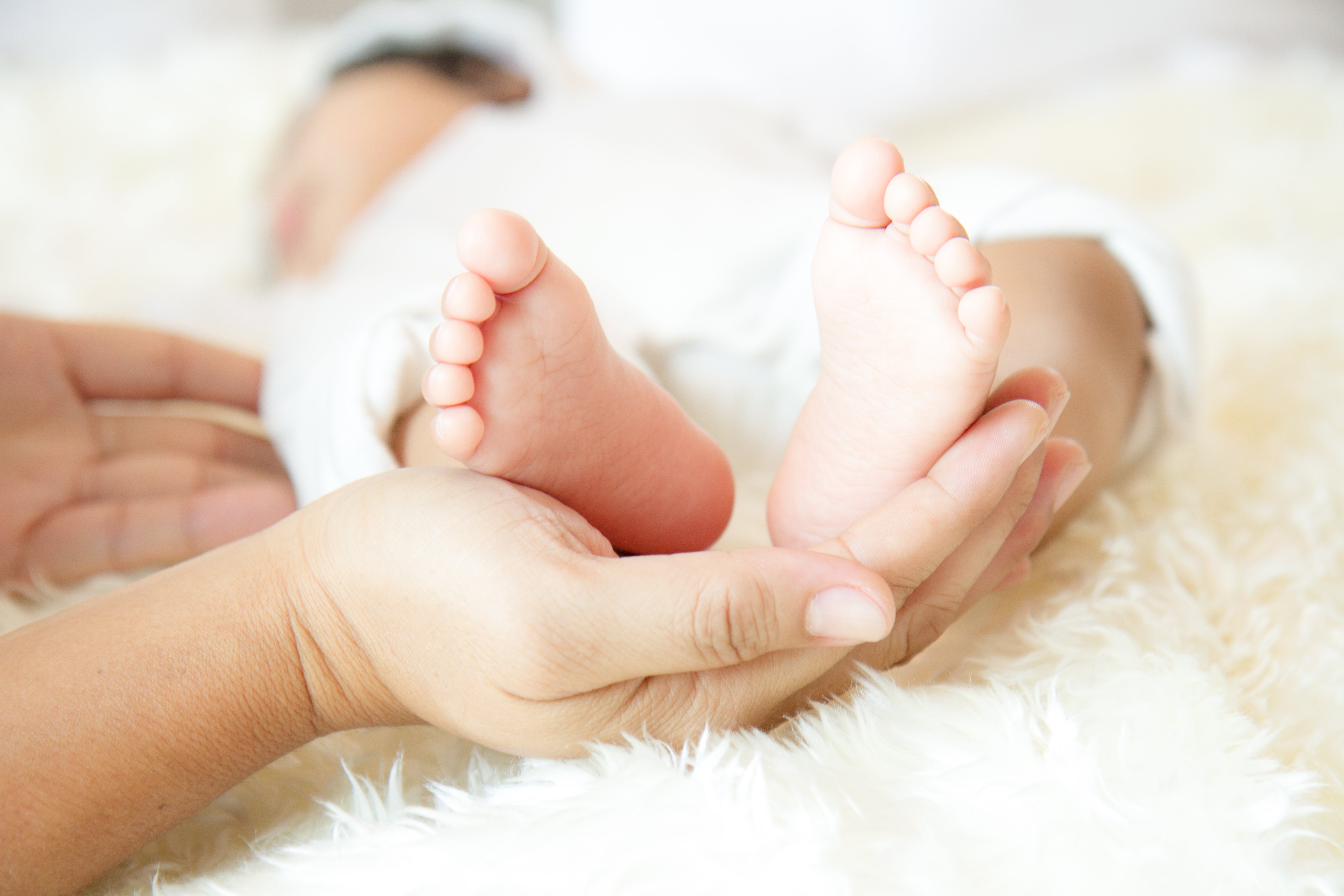 Les pieds d'un bébé dans les mains de sa mère. l Source: Shutterstock Les pieds d'un bébé dans les mains de sa mère. l Source: Shutterstock