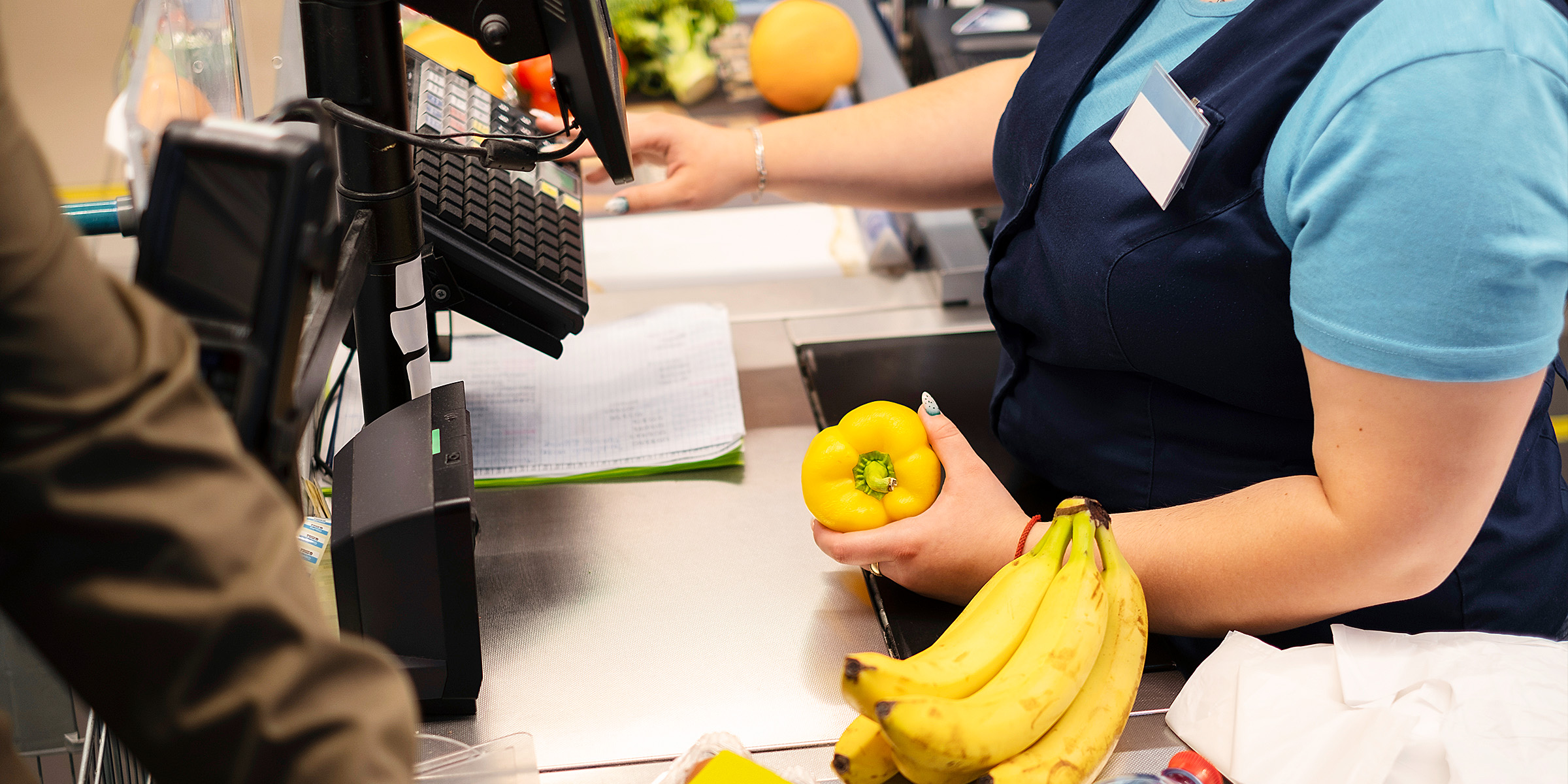 A cashier scanning items at the till | Source: Freepik