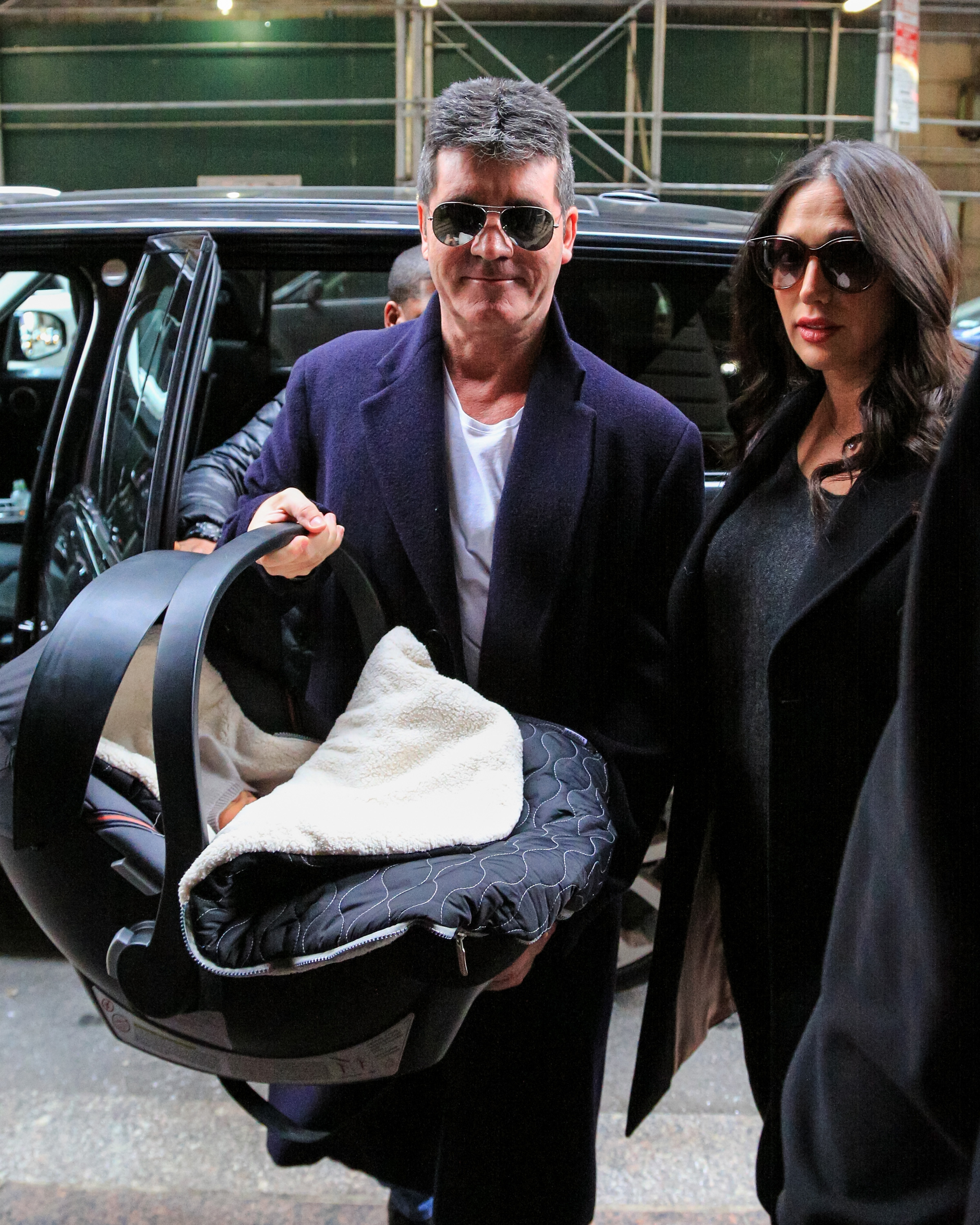 Simon Cowell and Lauren Silverman with their newborn son, Eric Cowell, arriving at their hotel on February 16, 2014, in New York. | Source: Getty Images