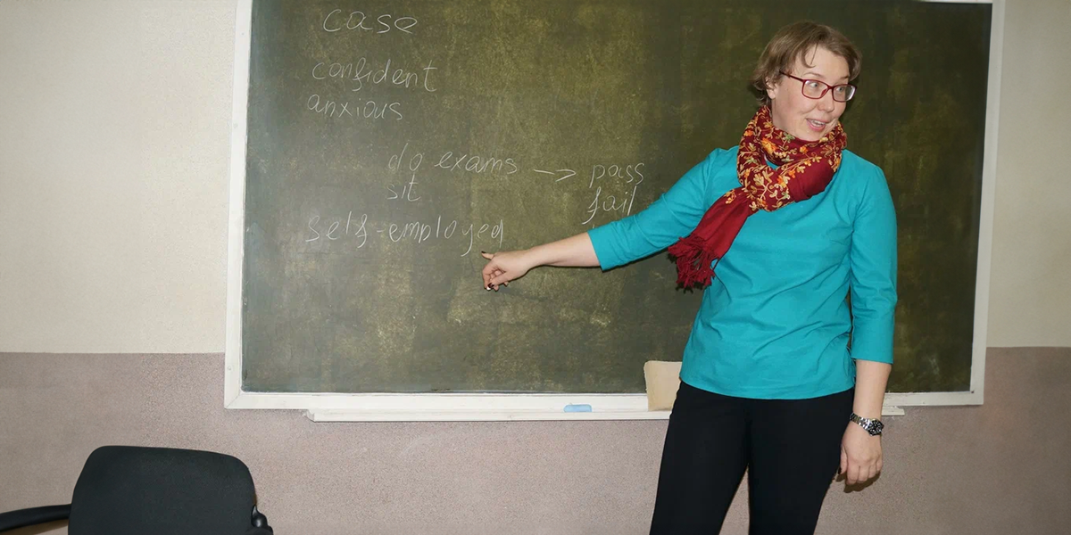 Teacher is standing at the blackboard | Source: Pexels