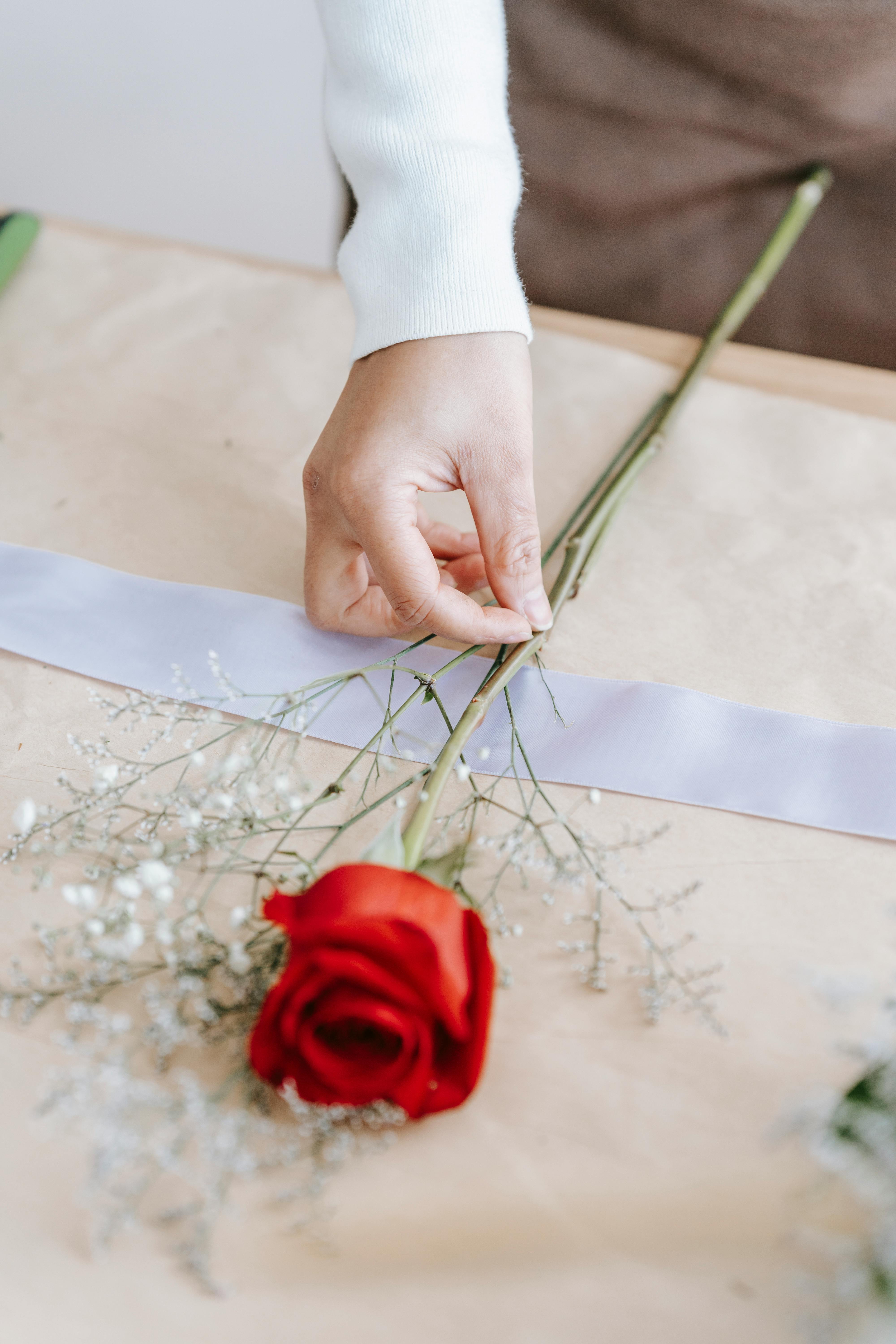 A rose on top of a wrapped gift | Source: Pexels