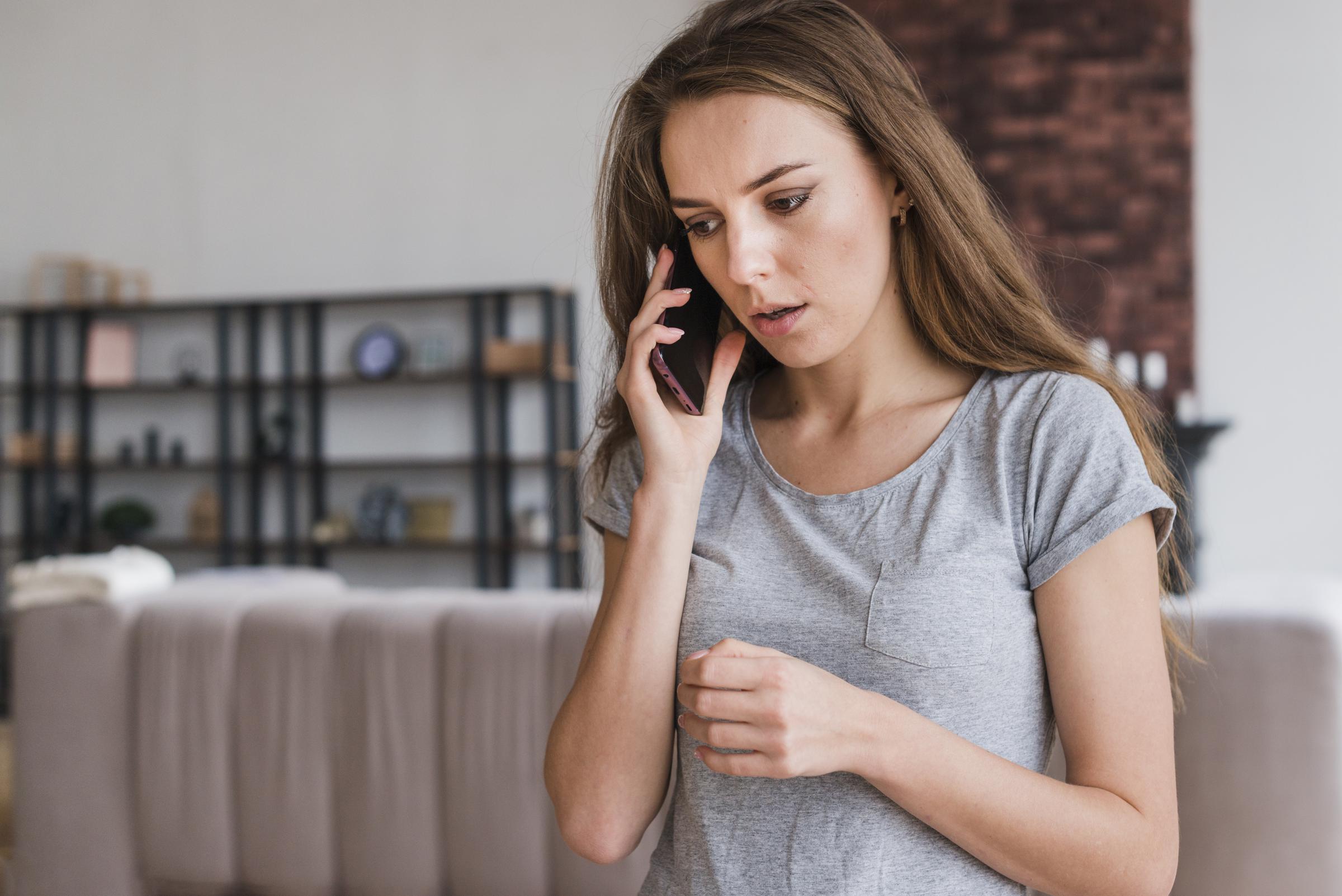 A distressed woman talking on the phone | Source: Freepik