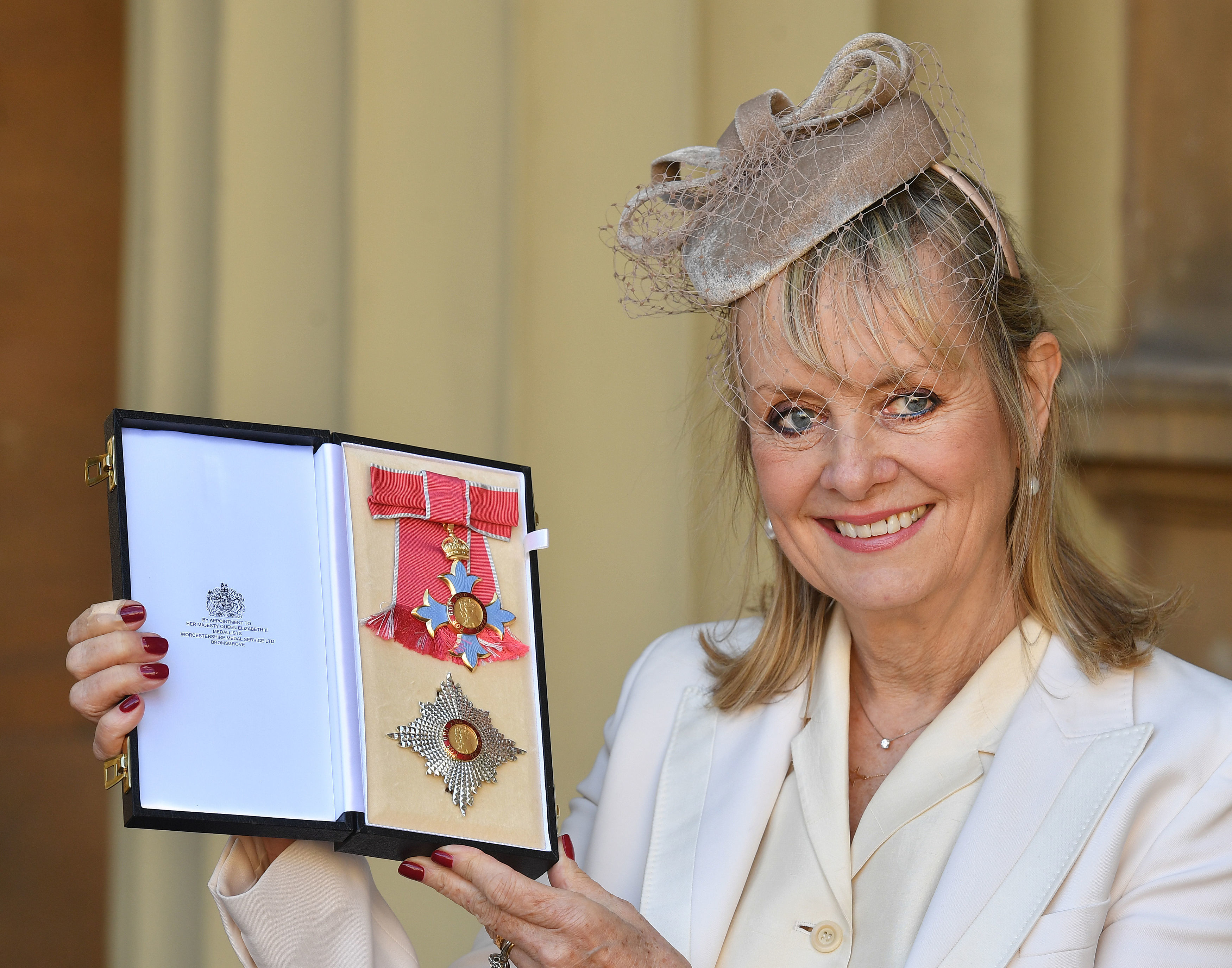 The model with her Dame Commander of the Order of the British Empire award in London on March 14, 2019. | Source: Getty Images