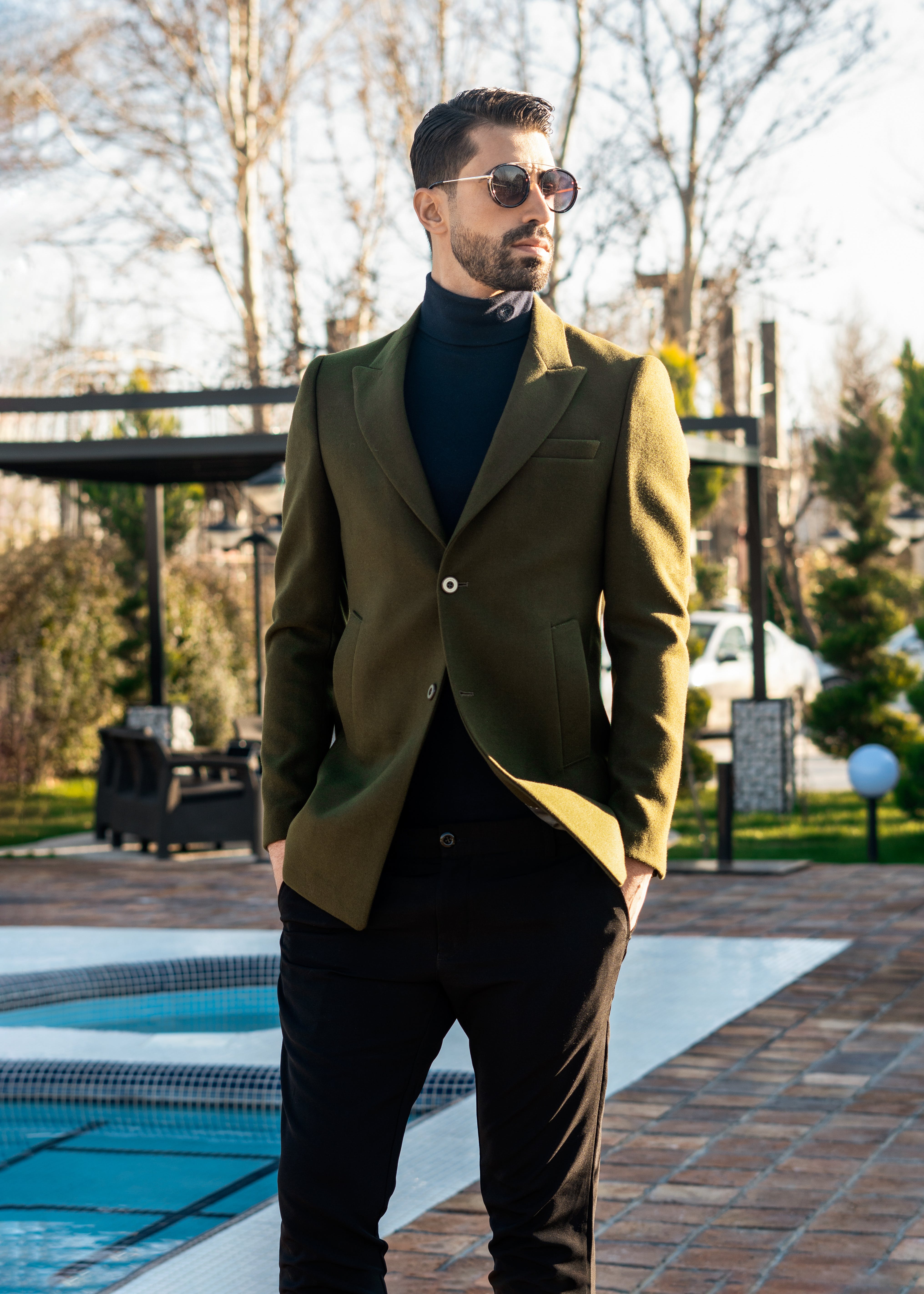 A stylish man standing by the pool. | Source: Pexels