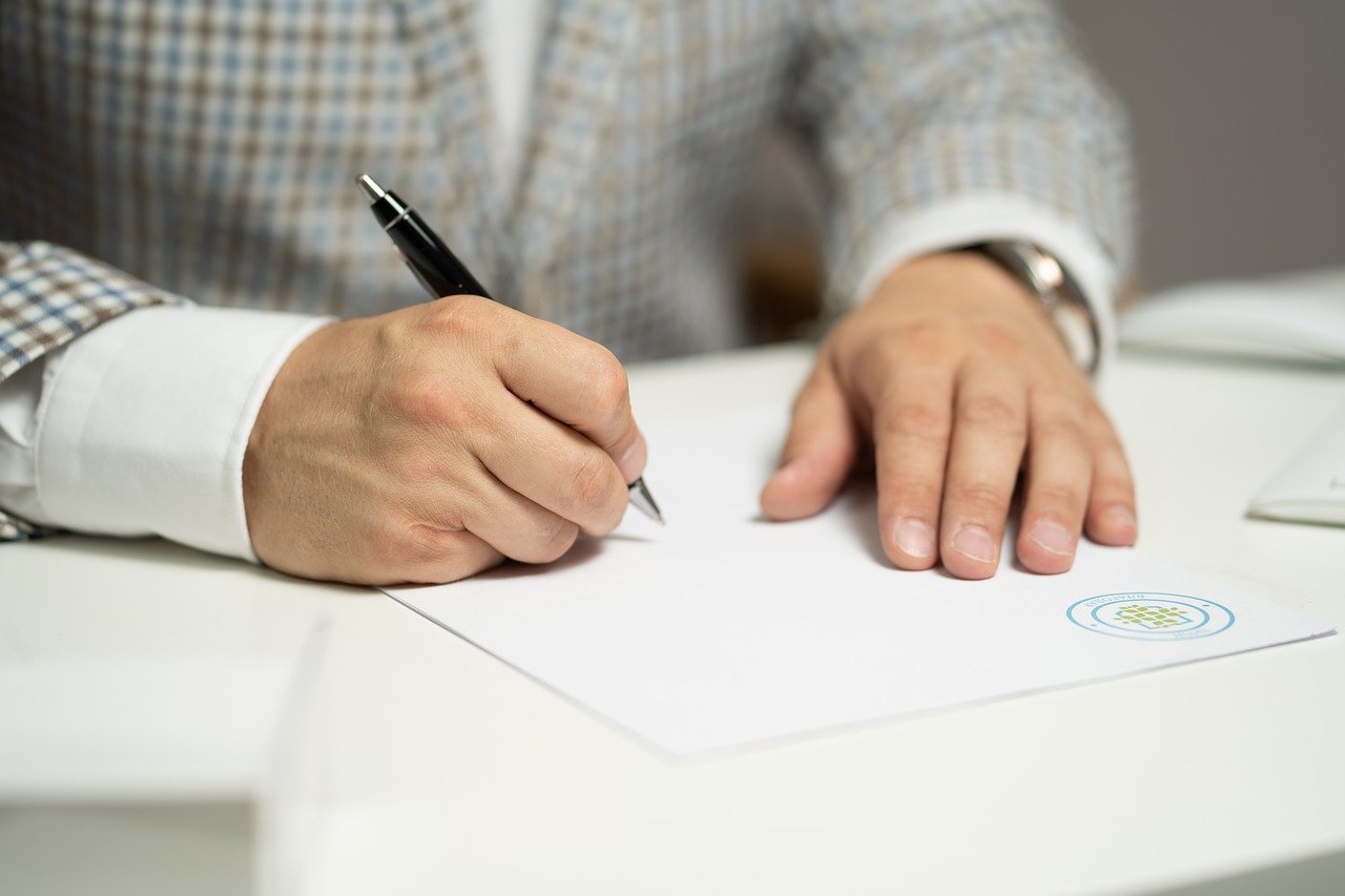 Hombre firmando un documento. | Foto: Pixabay
