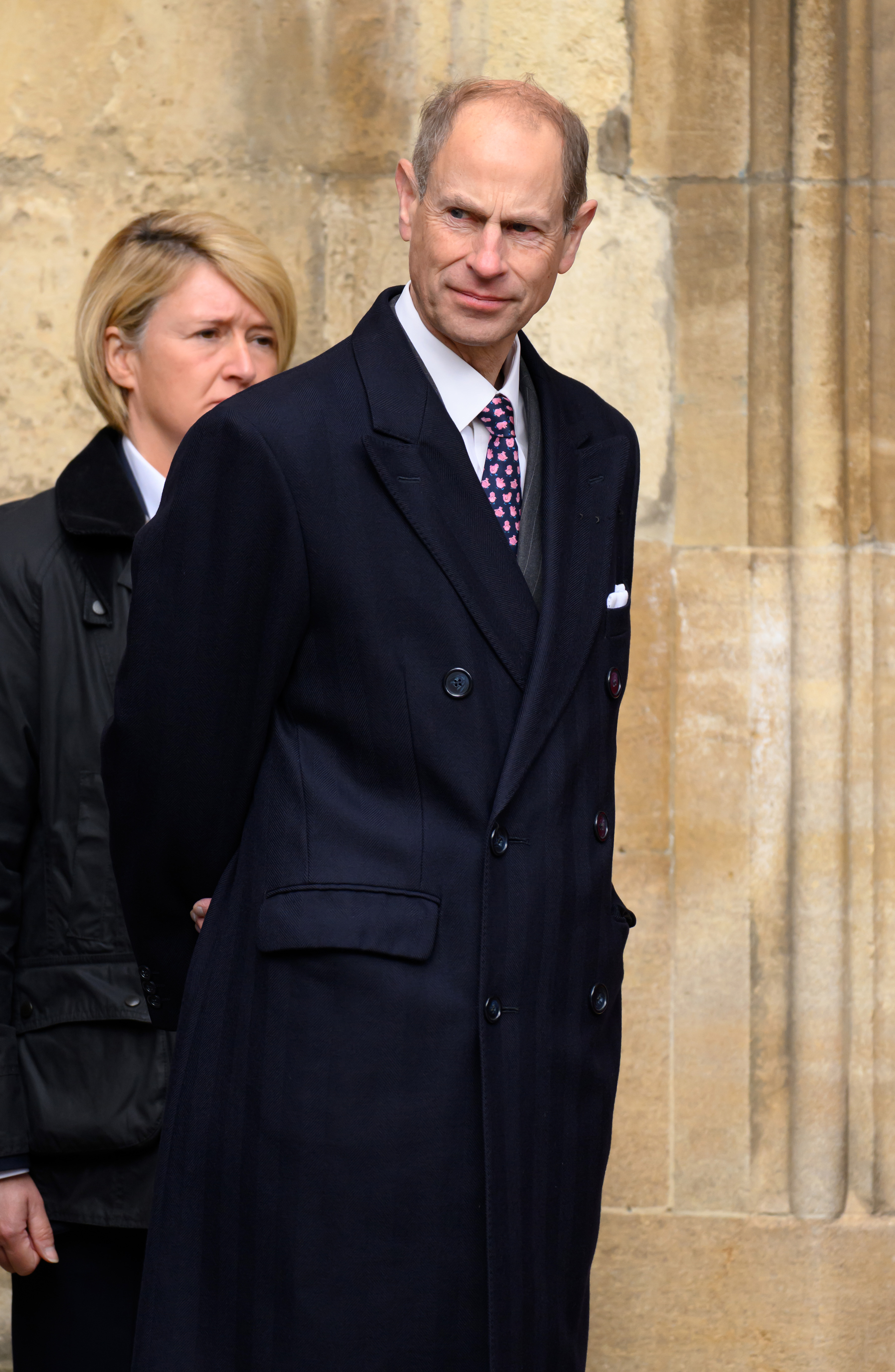 Prince Edward, Duke of Edinburgh, cuts a composed figure outside St George's Chapel at Windsor Castle on 5 April 2026, dressed in a navy double-breasted overcoat and a pink floral tie, a white pocket square folded neatly at his breast. He made the walk down to the chapel alongside his son, James, Earl of Wessex, as the royal family gathered for one of the most traditional services in the annual calendar.