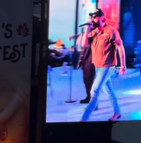 Nate Smith strides across the stage mid-performance, microphone raised to his mouth as he delivers his set in front of a brightly lit concert screen.| Source: Instagram/natesmith