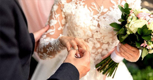 A groom putting the wedding ring on his bride. | Source: Shutterstock