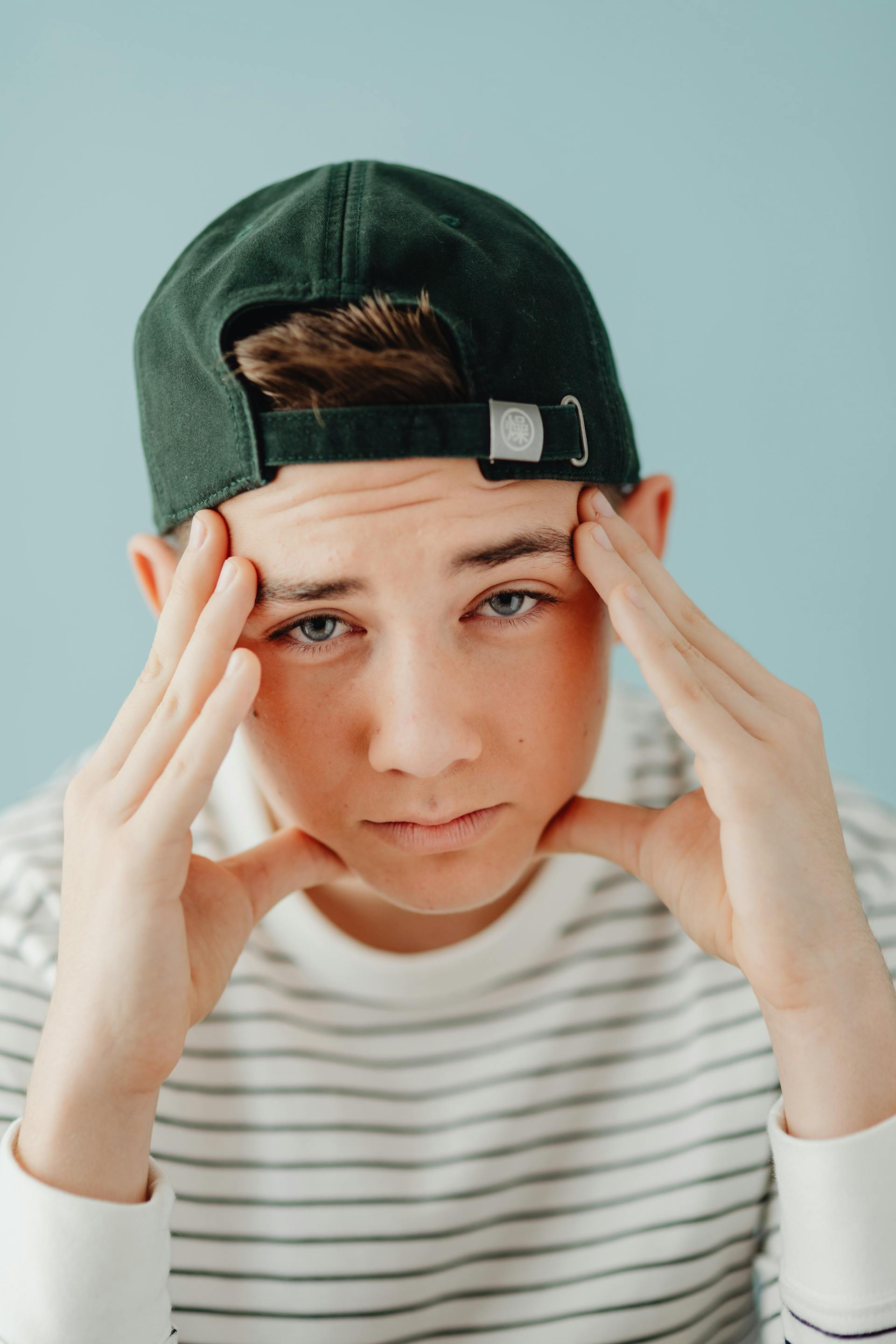 An annoyed teenage boy holding his head | Source: Pexels