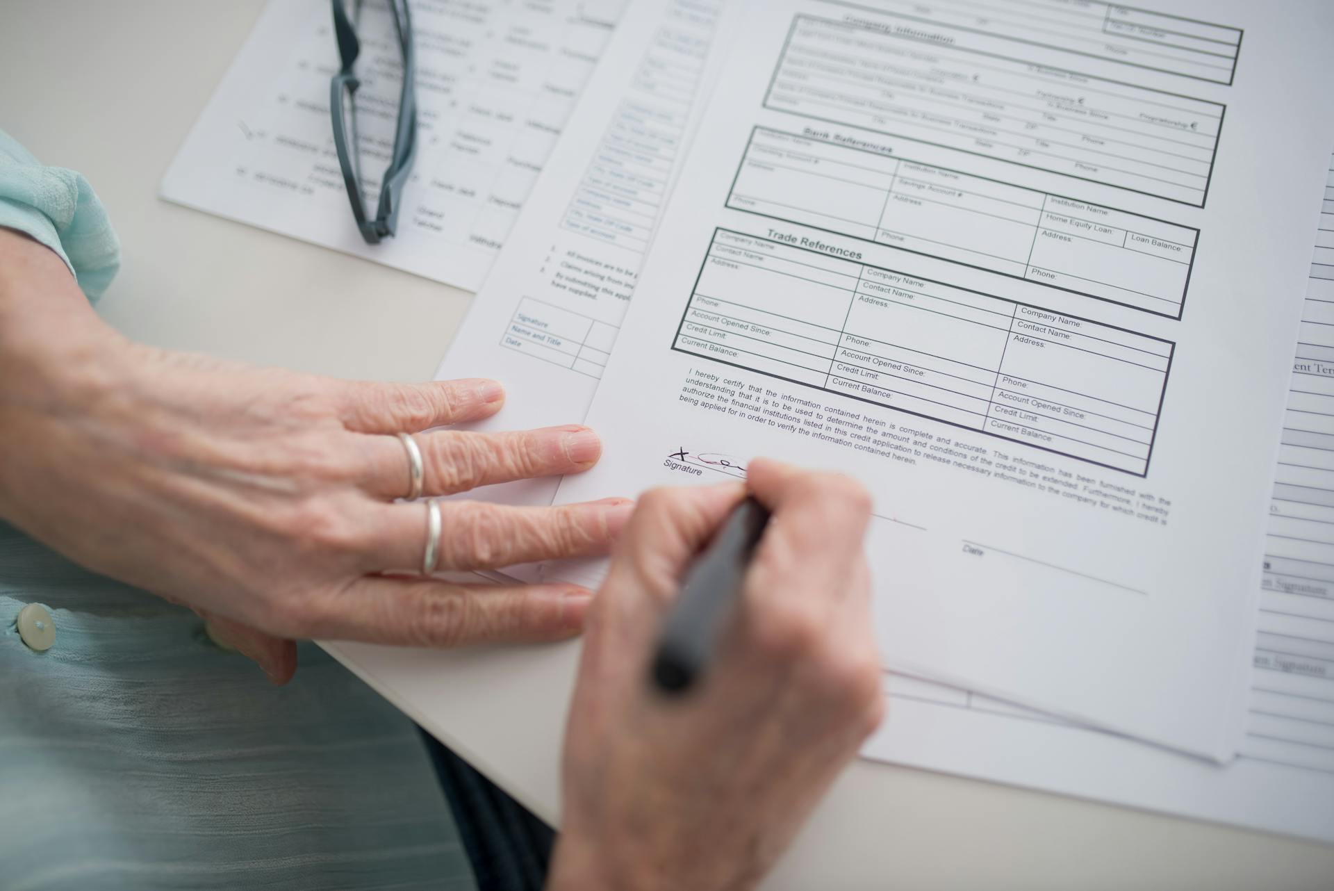 Uma mulher assinando um documento | Fonte: Pexels