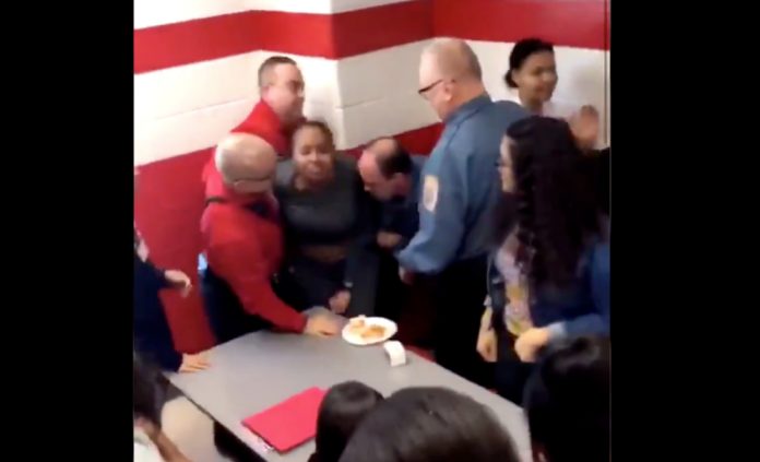 Screenshot from the video of a black student being brutally restrained by four security officers | Twitter: @iamdejmilann
