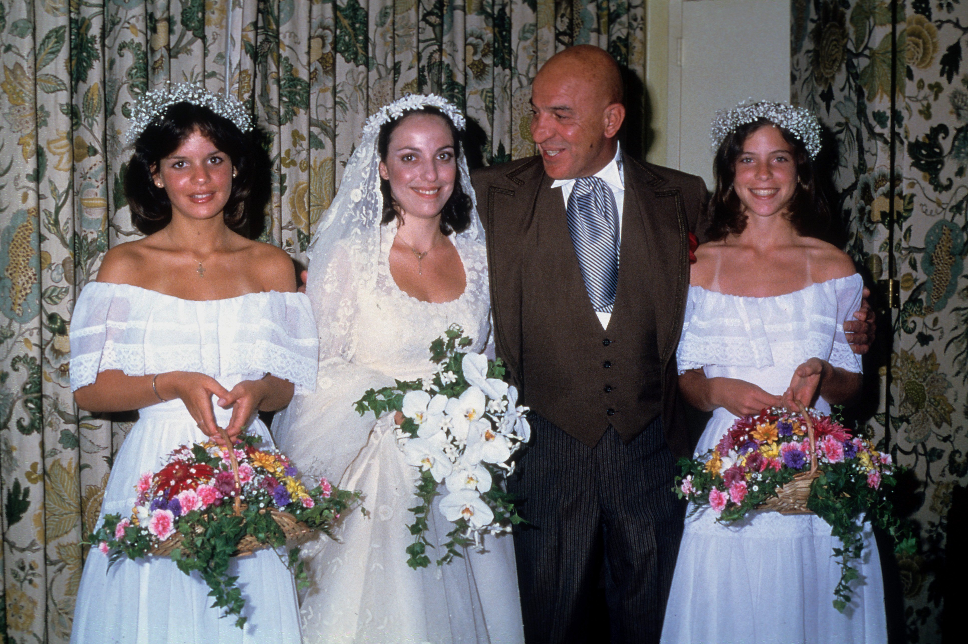 Actor Telly Savalas and his daughters pose for a portrait at Daughter Christina's Wedding 1991 in Los Angeles, California. | Source: Getty Images