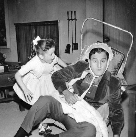 Danny Thomas and his television daughter, Angela Cartwright, play house in this publicity photo from the television program "Make Room for Daddy." | Source: Wikimedia Commons