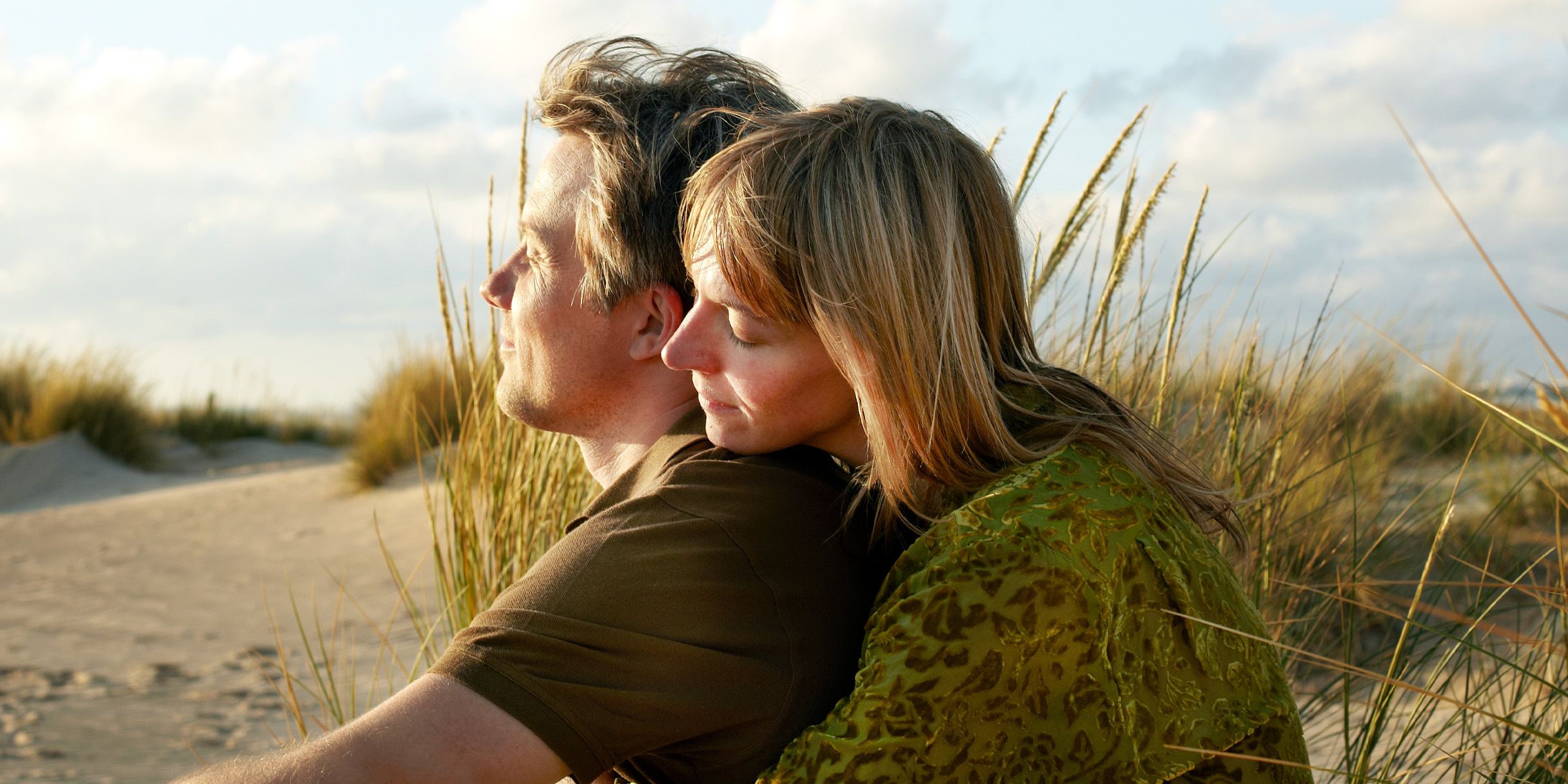 A couple sunbathing on a beach | Source: Getty Images