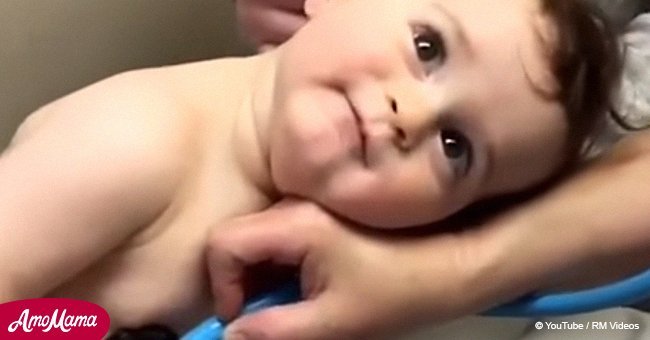 Adorable moment baby boy rests his head on nurse’s hand