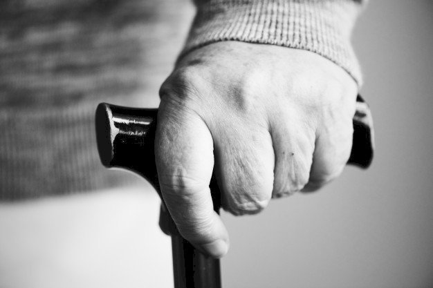 Schwarz-Weiß-Bild einer Hand am Gehstock | Quelle: Freepik